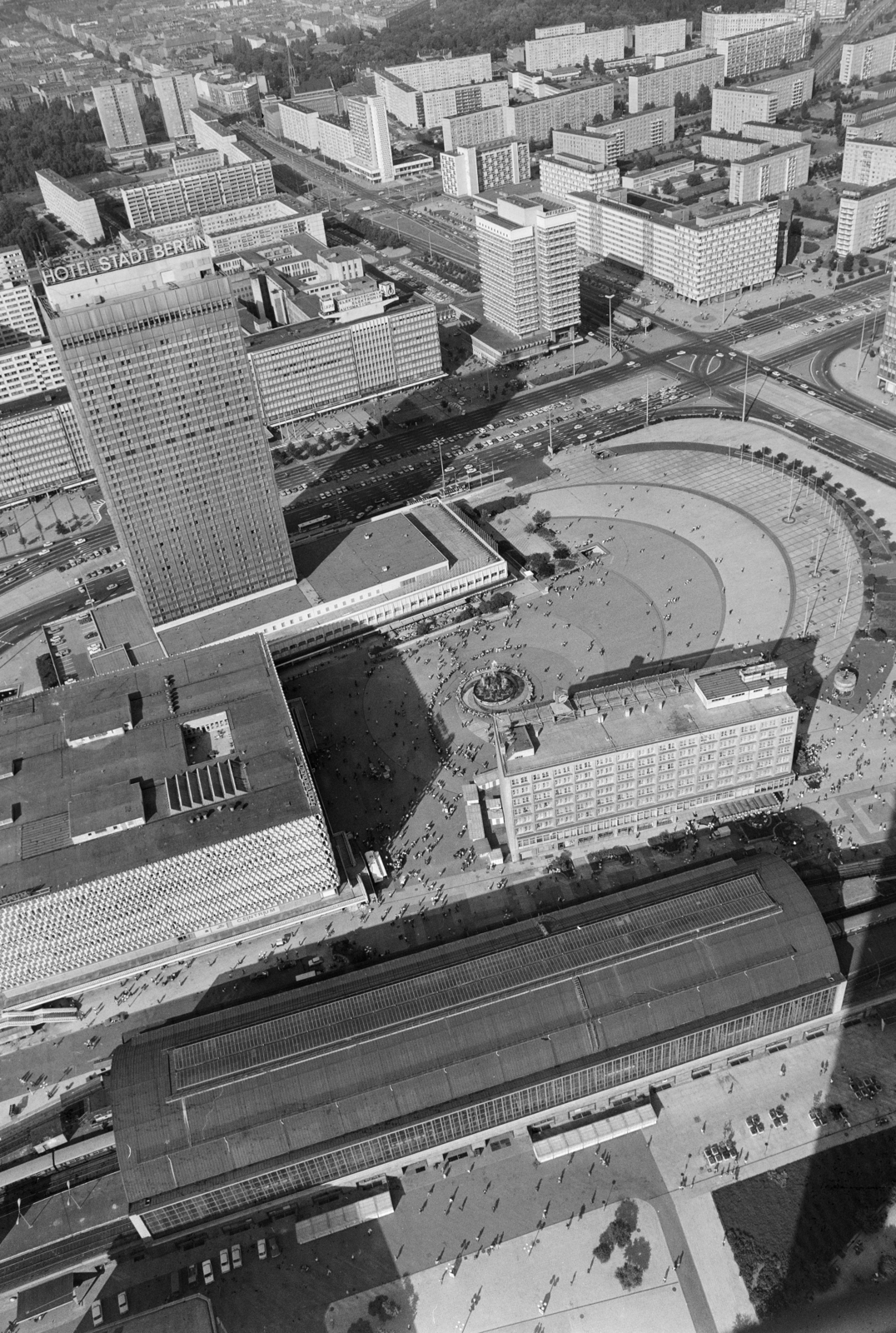 Németország, Berlin, Kelet-Berlin, kilátás a TV toronyból a Hotel Stadt Berlin felé, mögötte a Karl Marx Allee. Előtérben a Bahnhof Alexanderplatz, a HO-Centrum-Warenhaus (Centrum áruház) és a Berolinahaus, mögötte a Brunnen der Völkerfreundschaft (Népek barátsága szökökút) látható., 1980, Vimola Károly, NDK, Fortepan #266832