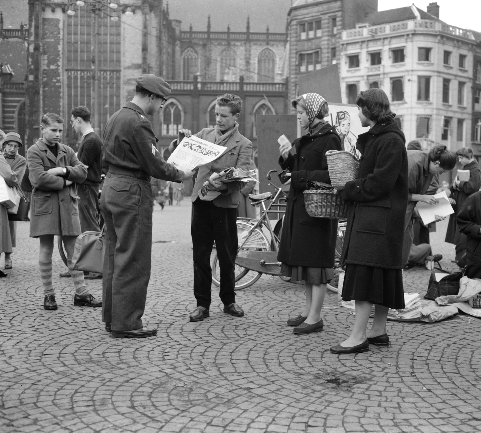 Netherlands, Amsterdam, Dam tér, a Magyarország megsegítésére indított, 1956-os adománygyűjtésekor, egyetemisták újságot árulnak., 1956, Nationaal Archief, youth, newspaper, solidarity, Dutch sign, bicycle, Fortepan #267180