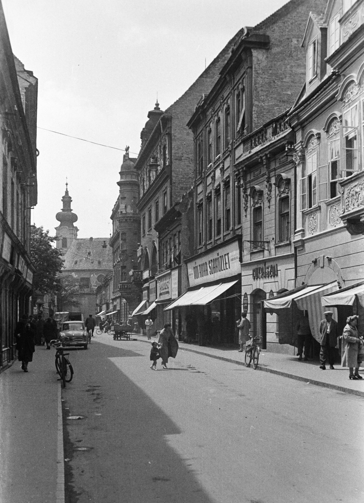 Hungary, Győr, Kazinczy utca a Széchenyi tér felől a Bécsi kapu (Köztársaság) téren álló Karmelita templom felé nézve., 1960, Kovács Annamária, bicycle, street view, pastry shop, girl, ribbon, Fortepan #267658