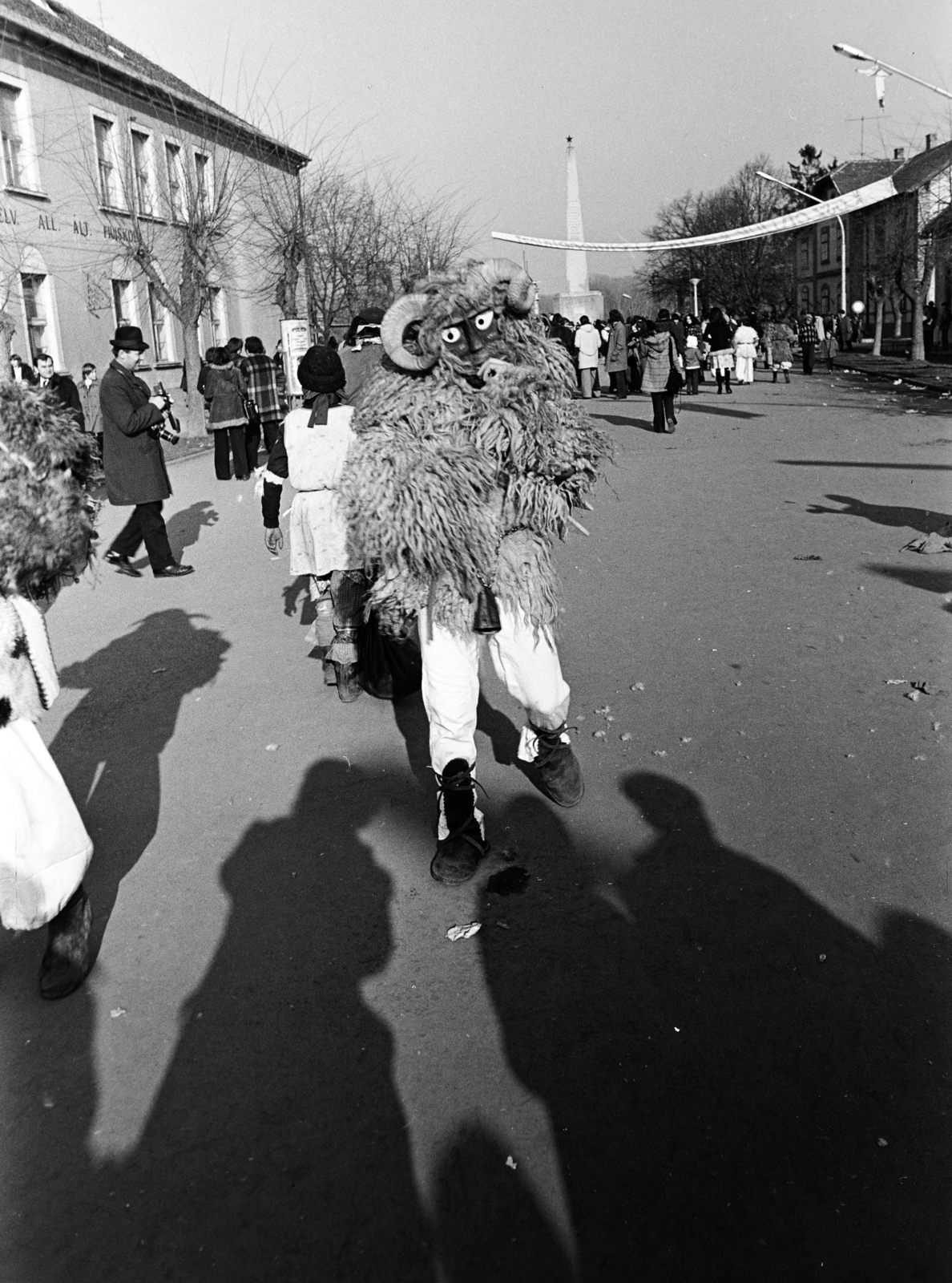 Hungary, Mohács, Szabadság utca, busójárás idején. Háttérben a szovjet hősi emlékmű., 1975, Dorics István, Fortepan #267950