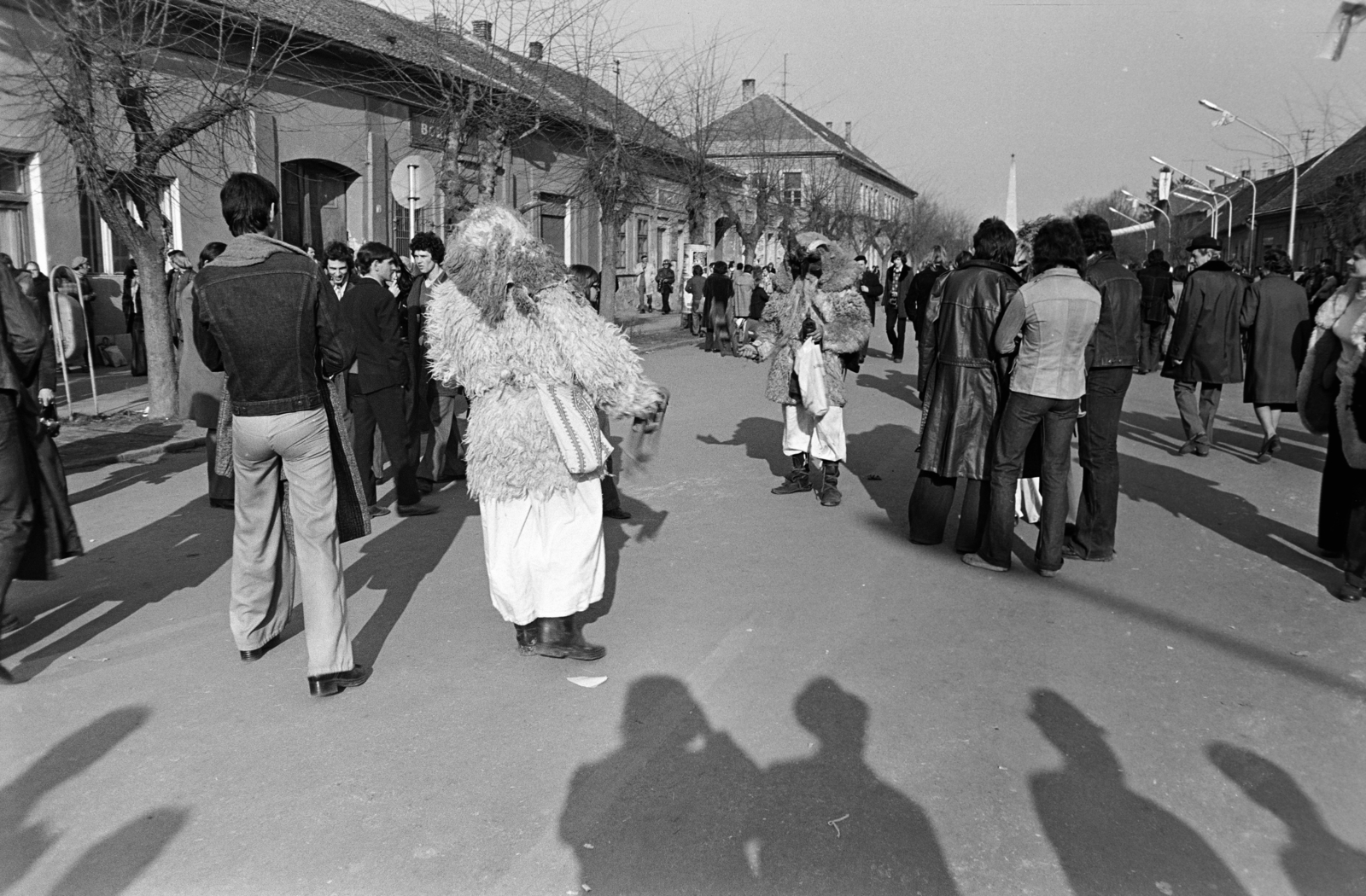 Magyarország, Mohács, Szabadság utca, busójárás idején. Háttérben a szovjet hősi emlékmű., 1975, Dorics István, Fortepan #267954