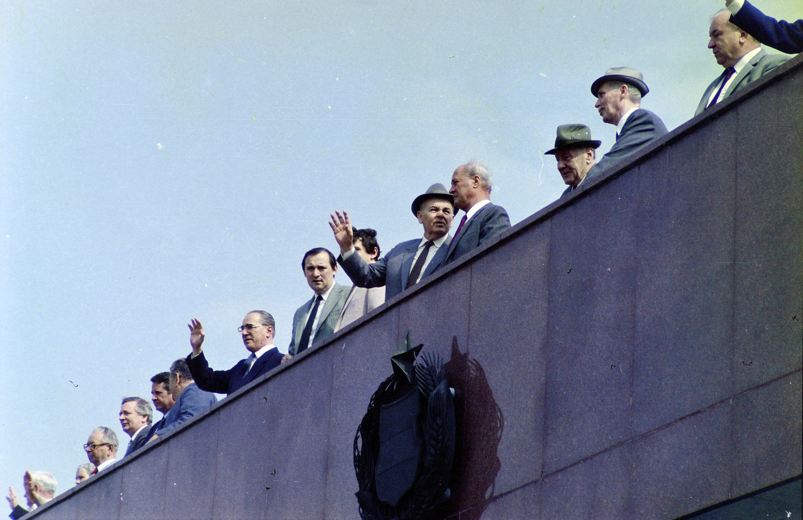 Magyarország, Budapest XIV., Ötvenhatosok tere (Felvonulási tér), május 1-i felvonulás, a dísztribünön Kállai Gyula, Szűrös Mátyás, Berecz János, ?., Óvári Miklós, Maróthy László, Hámori Csaba (takarva), Németh Károly, Losonczi Pál, Lázár György, Havasi Ferenc, 1986, Glósz András, Budapest, címer, integetés, politikus, színes, Fortepan #268505