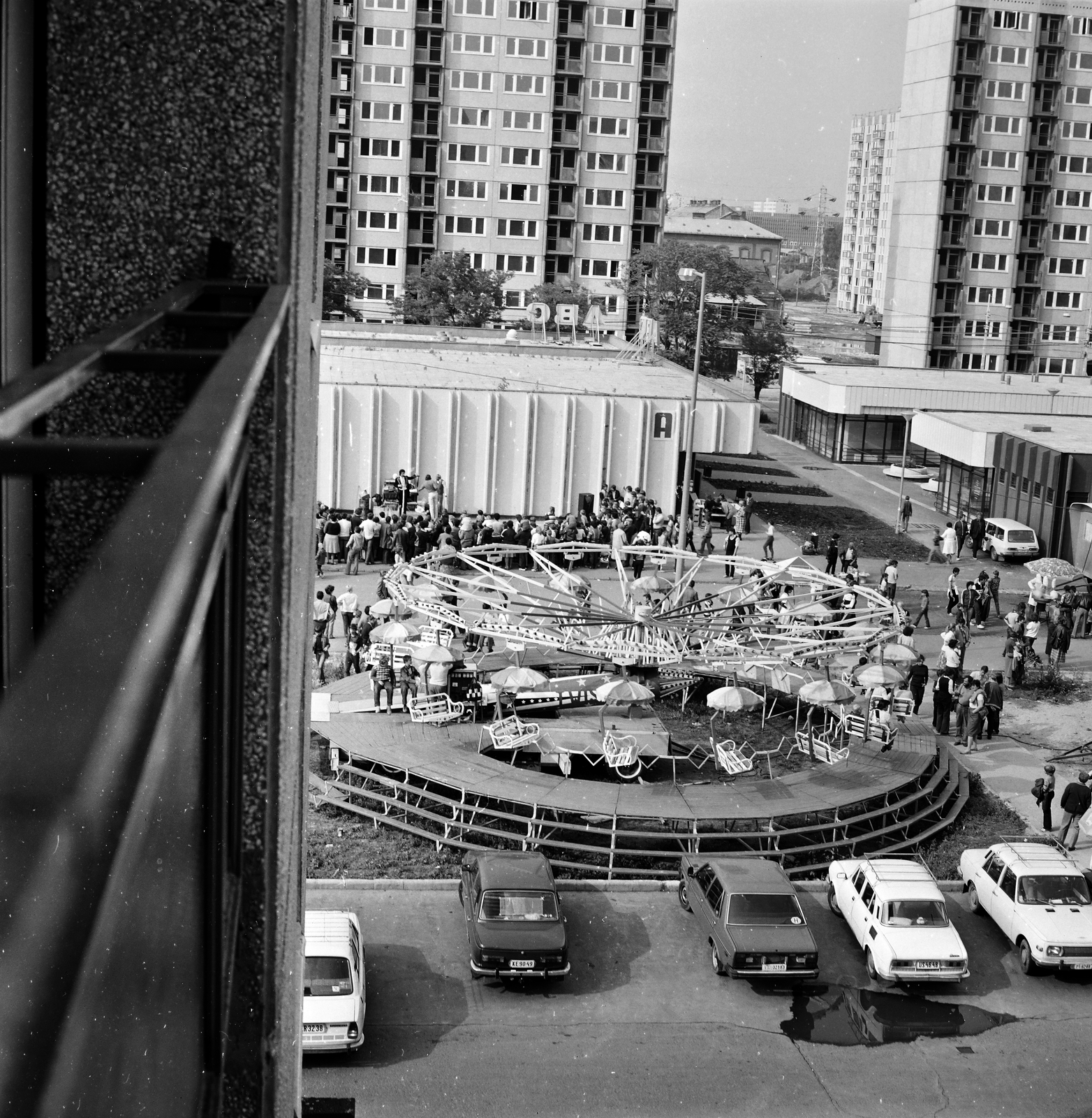 Magyarország, Budapest XIII., kilátás a Kárpát utca 37-es számú házból a Tisza (Tisza Antal) utca melletti vurstlira. Balra a szolgáltatóházak közötti sétálóutca a Dráva utcához vezet., 1983, Glósz András, körhinta, vurstli, Budapest, Fortepan #268544