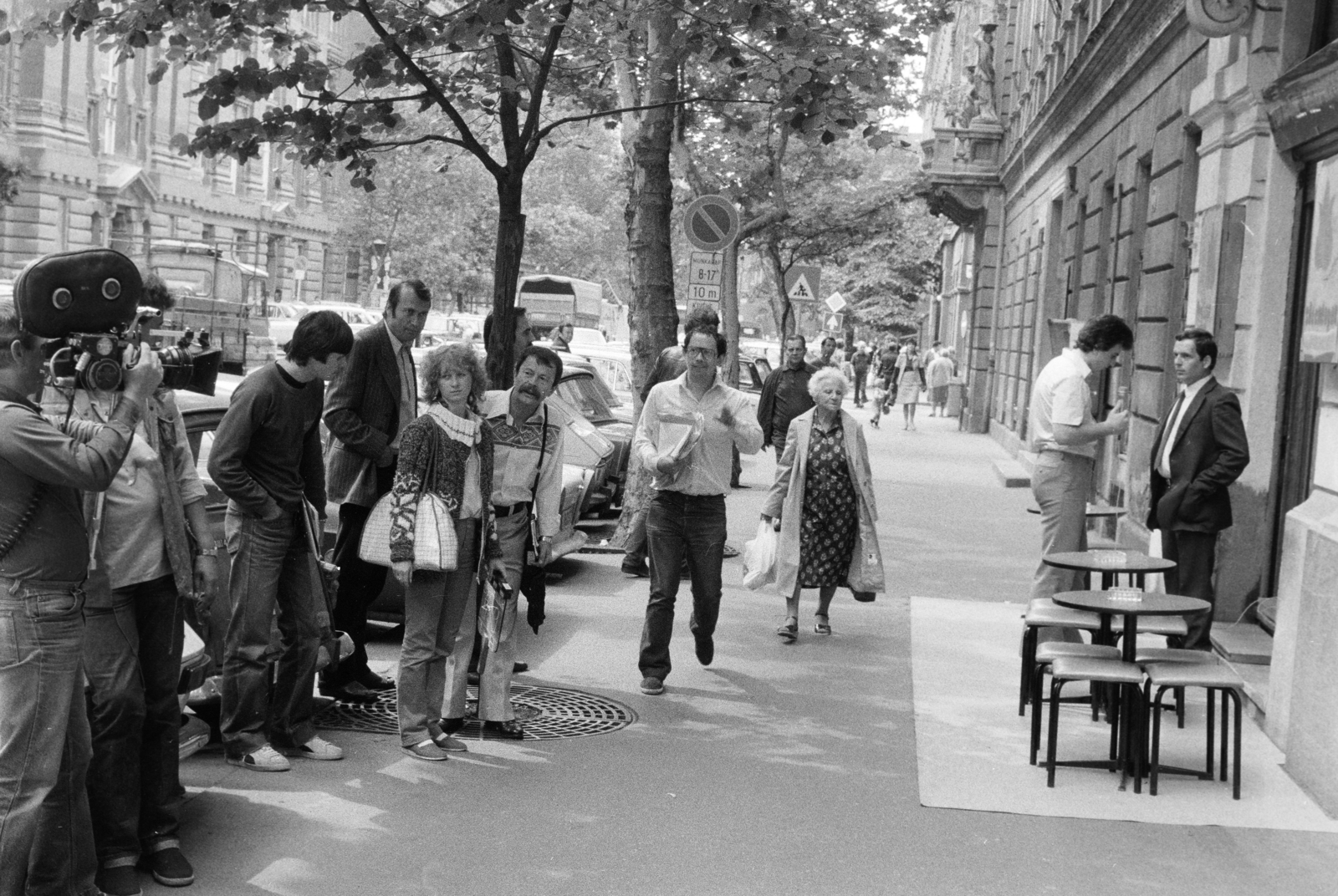 Magyarország, Budapest V., Nádor utca (Münnich Ferenc utca) a felvétel a 34. számú ház előtt készült. Sütő Péter újságíró, műsorvezető, rendező, szerkesztő riportot készít az MTV Reflektor Magazinjának., 1983, Kanyó Béla, Budapest, filmforgatás, filmkamera, interjú, riporter, Fortepan #268716