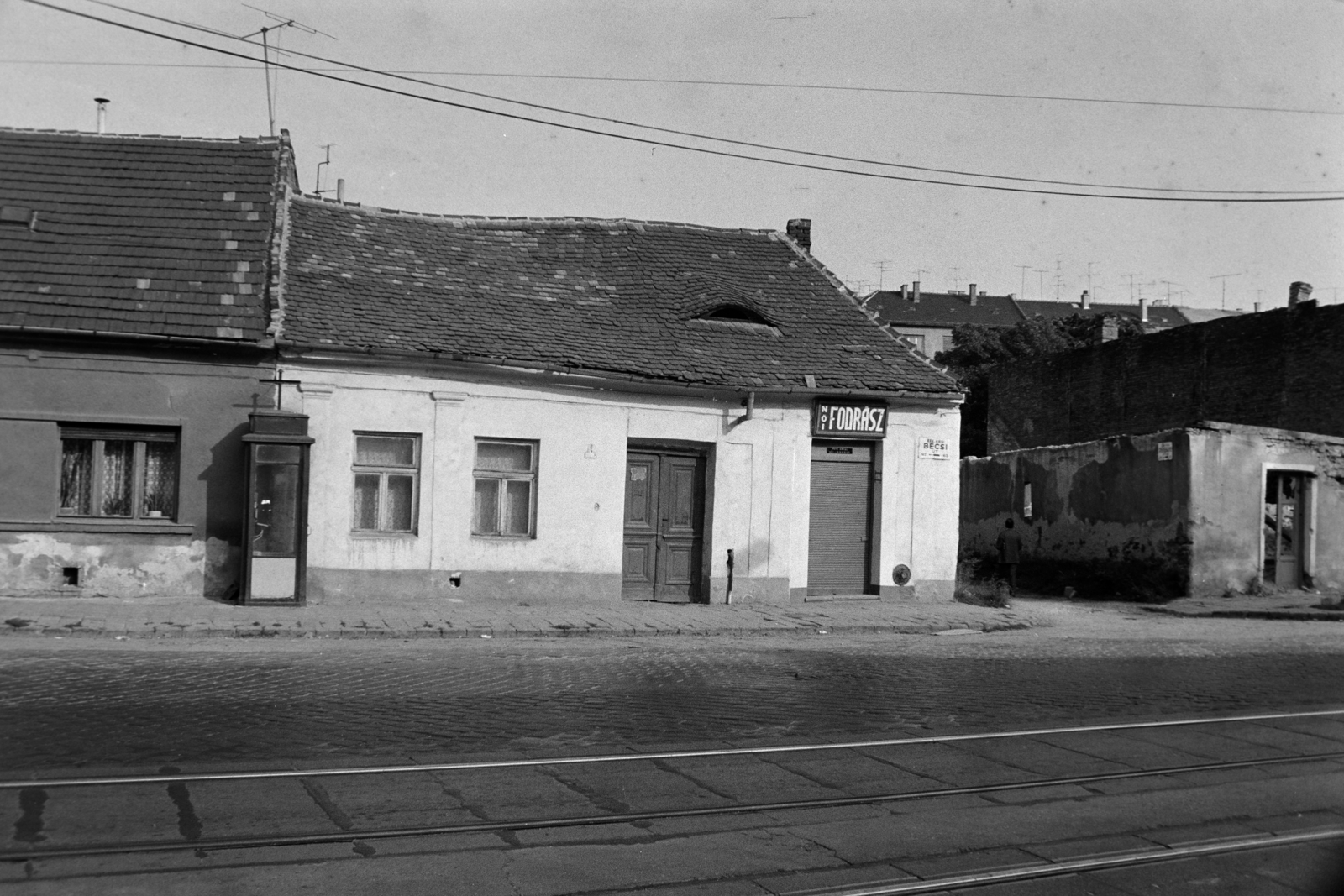 Magyarország, Budapest III., Bécsi út, a későbbi Puskás Öcsi térnél, szemben jobbra a Dereglye utca torkolata, háttérben a Lajos utca melleti épületek láthatók., 1980, Kanyó Béla, telefonfülke, cégér, Budapest, Fortepan #269072