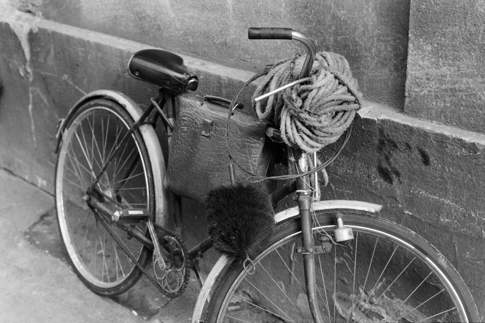 Magyarország, Budapest VII., Akácfa utca, munkába induló kéményseprő kerékpárja az 57. számú házban lévő Fővárosi Ké­ményseprő és Tüzelés­­technikai Szolgáltató Vál­lalat irodájának és öltözőjének bejárata közelében., 1983, Kanyó Béla, Budapest, aktatáska, kötél, kefe, kerékpár, kéményseprő, Fortepan #269371