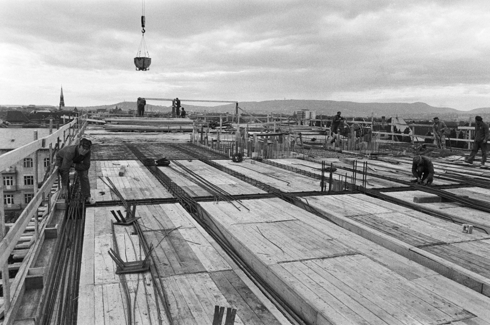 Hungary, Budapest XIV., Thököly út 97-101., a Pest Megyei Bíróság építkezése, háttérben balra a Rózsafüzér Királynéja-templom tornya, távolabb a budai hegyek látszanak., 1970, Középületépítő Vállalat - Kreszán Albert - Koczka András - Kemecsei József, Budapest, construction, Best of, Fortepan #269533