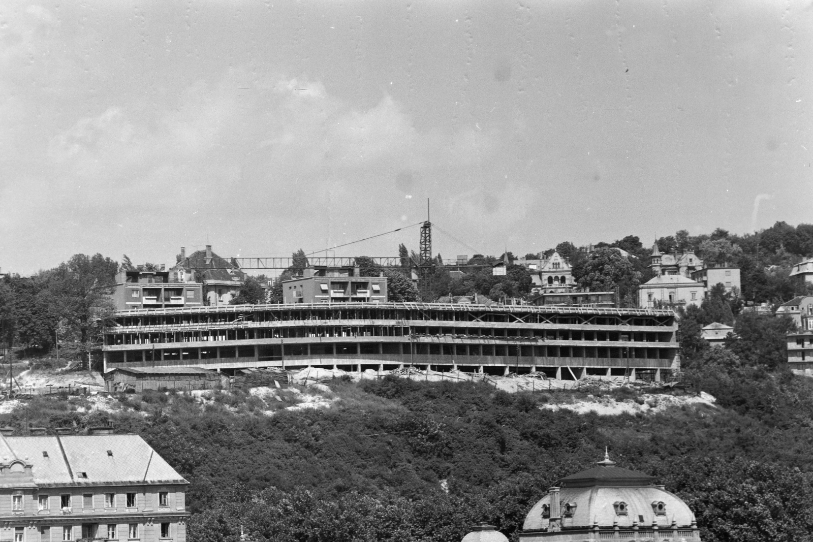 Magyarország, Budapest II., az épülő SZOT szálló a Rózsadombon, előtérben a Lukács fürdő kupolája látható., 1969, Középületépítő Vállalat - Kreszán Albert - Koczka András - Kemecsei József, Budapest, szálloda, hegyoldal, építkezés, Fortepan #269580