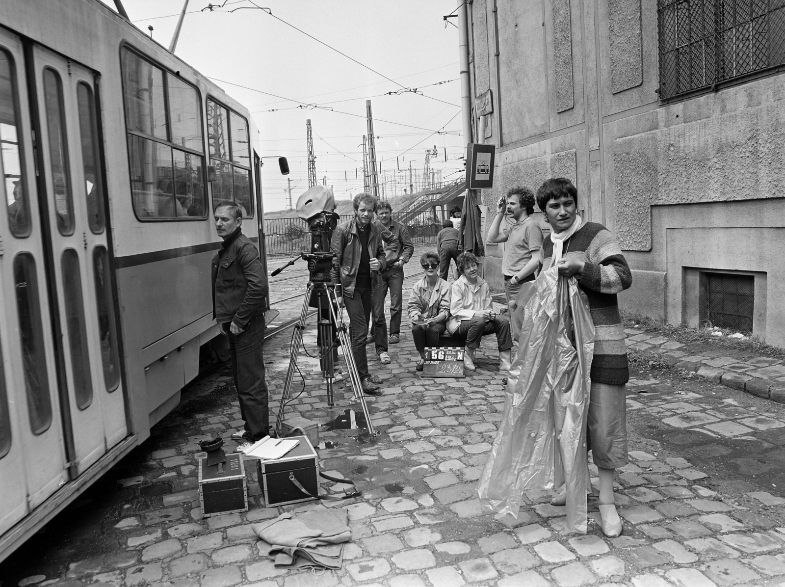Hungary, Budapest X., Kolozsvári utca, a felvétel a W című kisjátékfilm (munkacíme "Egy ember") forgatásakor, a BKV Őrház Áramátalakító előtt készült. Szemben bőrkabátban Halász Gábor operatőr látható., 1982, Ladinek Viktor, tram, Budapest, movie camera, clapperboard, Fortepan #269785
