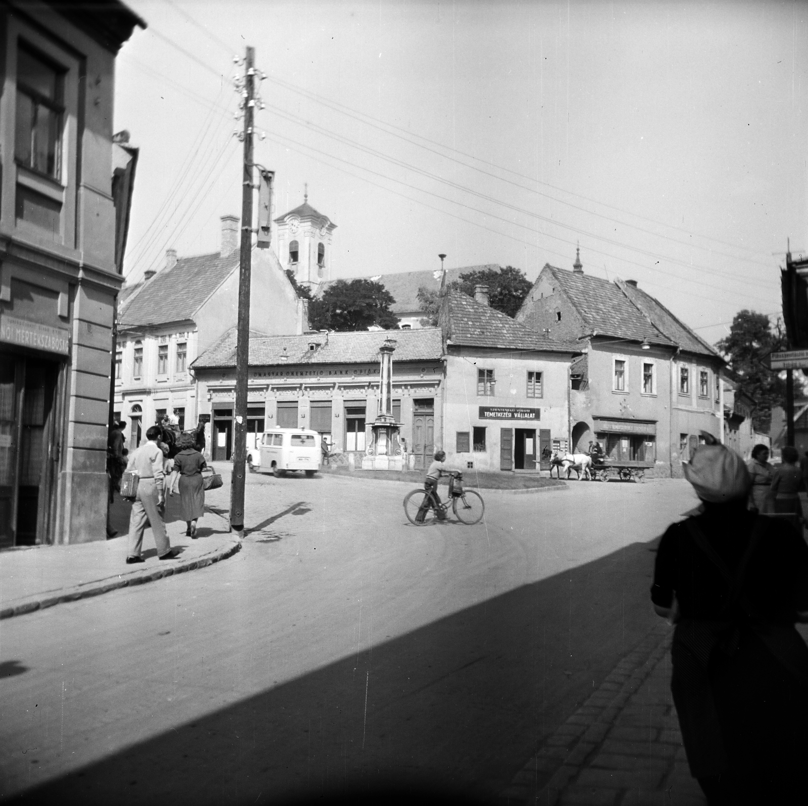 Magyarország, Szentendre, Fő (Marx) tér, középen a Szerb (kalmár) kereszt talapzata látható kereszt nélkül, háttérben a Keresztelő Szent János-templom., 1958, Vozárik Edit, lovaskocsi, utcakép, mentőautó, villanypózna, kerékpár, Fortepan #270143