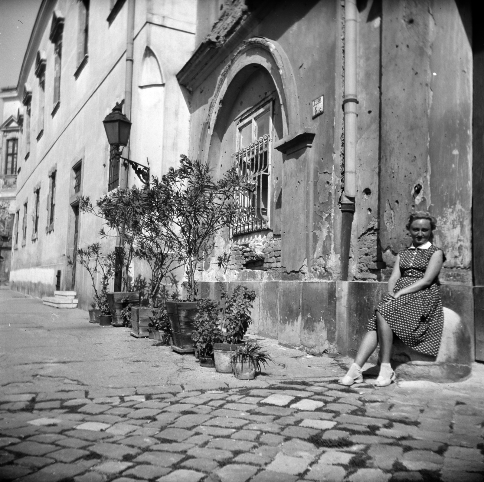 Hungary, Budapest I., Úri utca, a felvétel a 19. számú ház előtt készült., 1958, Vozárik Edit, Budapest, gas lamp, bullet hole, dotted dress, curb, Fortepan #270153