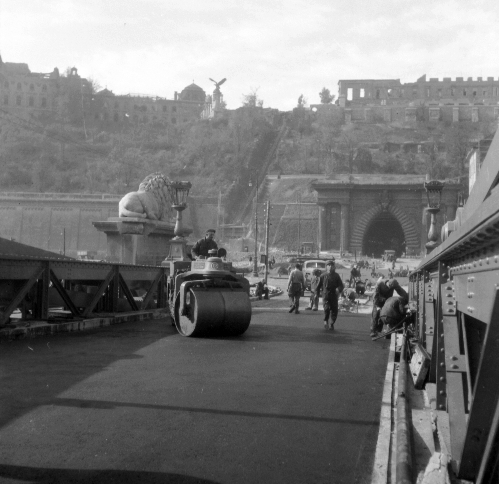 Hungary, Budapest I., Széchenyi Lánchíd az újjáépítéskor. Szemben a Clark Ádám tér és az Alagút., 1949, UVATERV, construction, tunnel, bridge building, Turul sculpture, road roller, stone lion, Budapest, suspension bridge, William Tierney Clark-design, Fortepan #27052