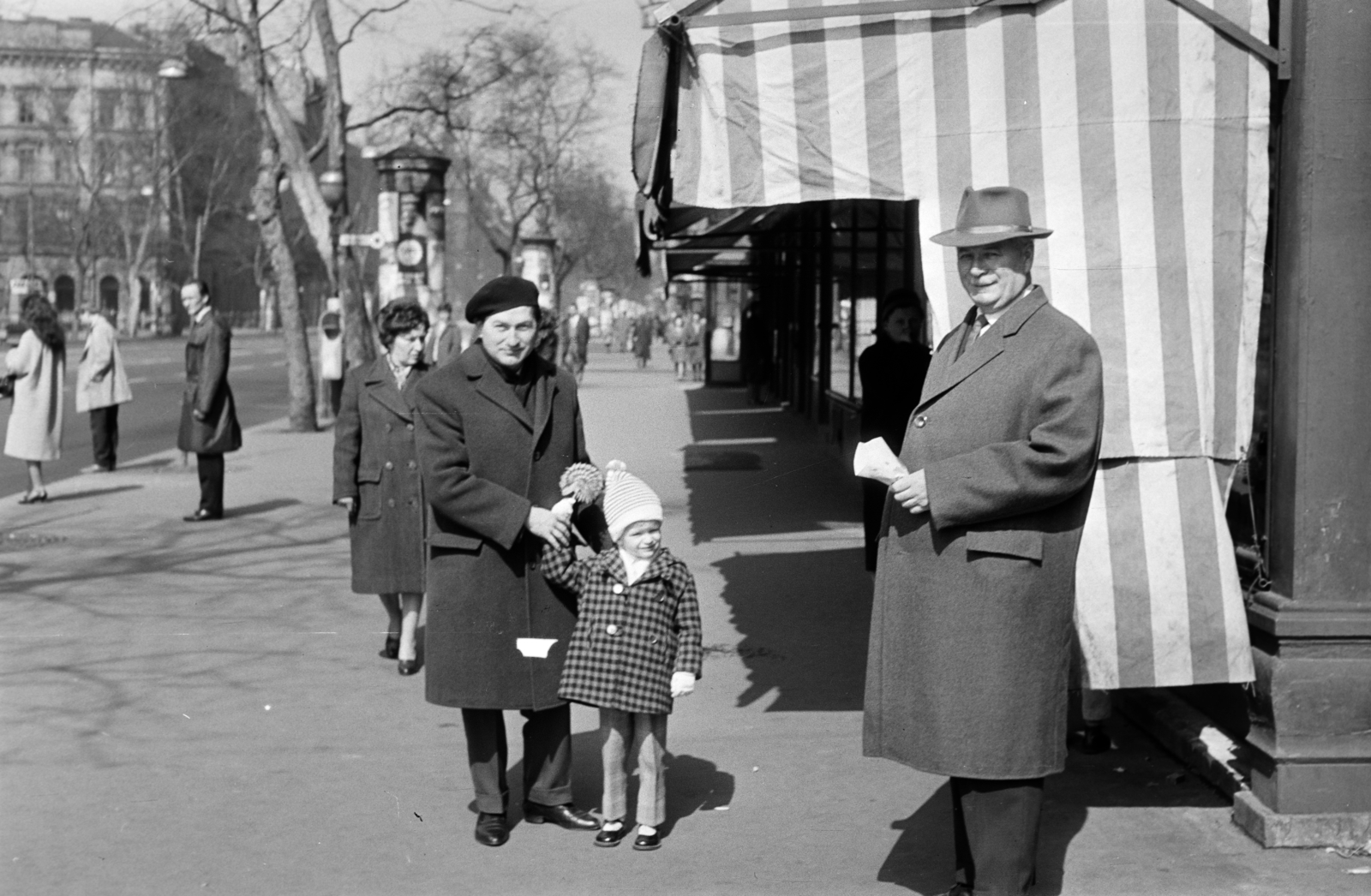 Magyarország, Budapest VI., Bajcsy-Zsilinszky út, szemben a kisgyermekkel Fodor András költő. A felvétel az Andrássy út (Népköztársaság útja) sarkán álló épület előtt készült, balra a Szent István tér sarkán álló ház látható., 1965, Fodor András örökösei, napellenző, Budapest, Fortepan #270882