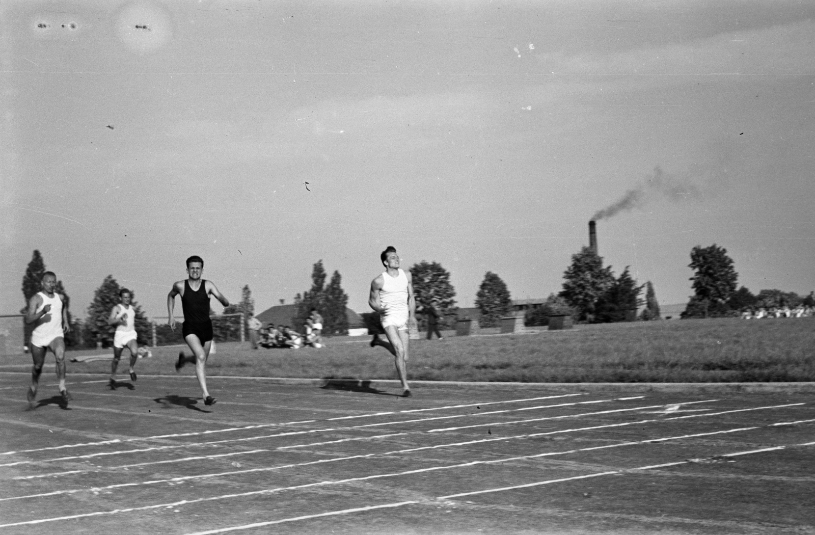 Magyarország, Pécs, a felvétel a Pedagógiai Főiskola (később Pécsi Tudományegyetem) sportpályáján készült. Háttérben a Pannónia Sörgyár kéménye látható., 1957, Lipovits Károly, sportpálya, futás, Fortepan #271140