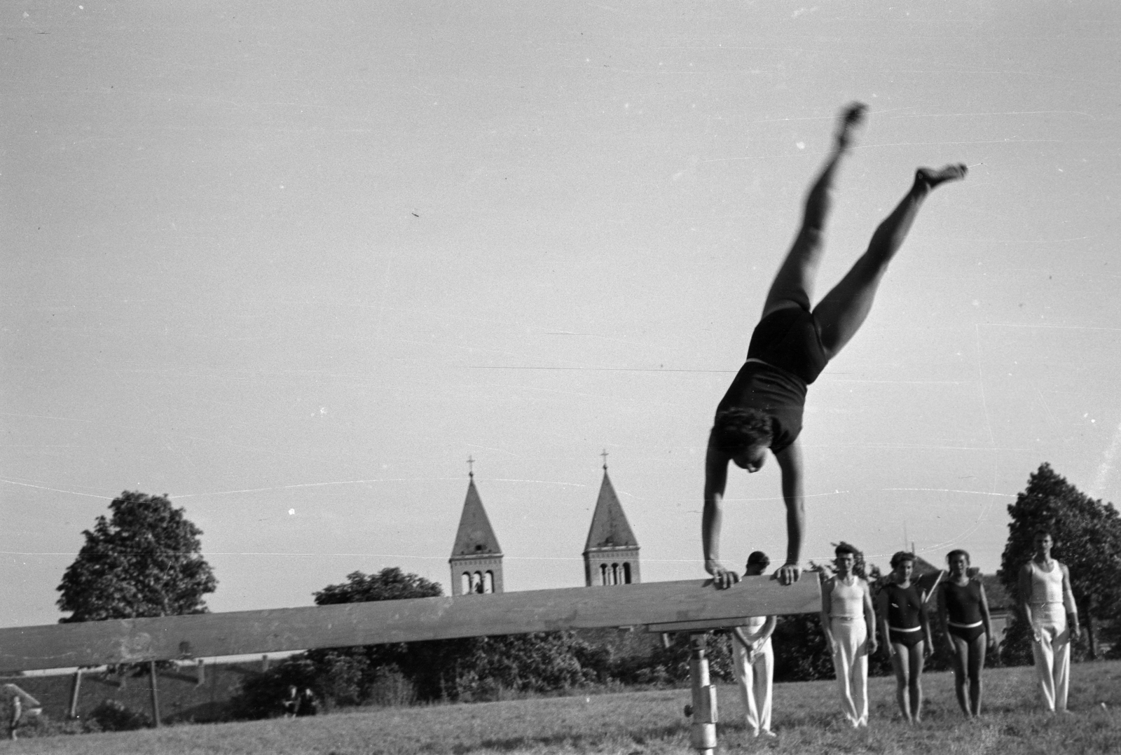 Hungary, Pécs, Ifjúság útja 6., a Pedagógiai Főiskola (később Pécsi Tudományegyetem) sportpályája. Háttérben a Jézus Szíve (Pius) templom tornyai., 1958, Lipovits Károly, feat, handstand, Exercise Equipment, beam, Fortepan #271251