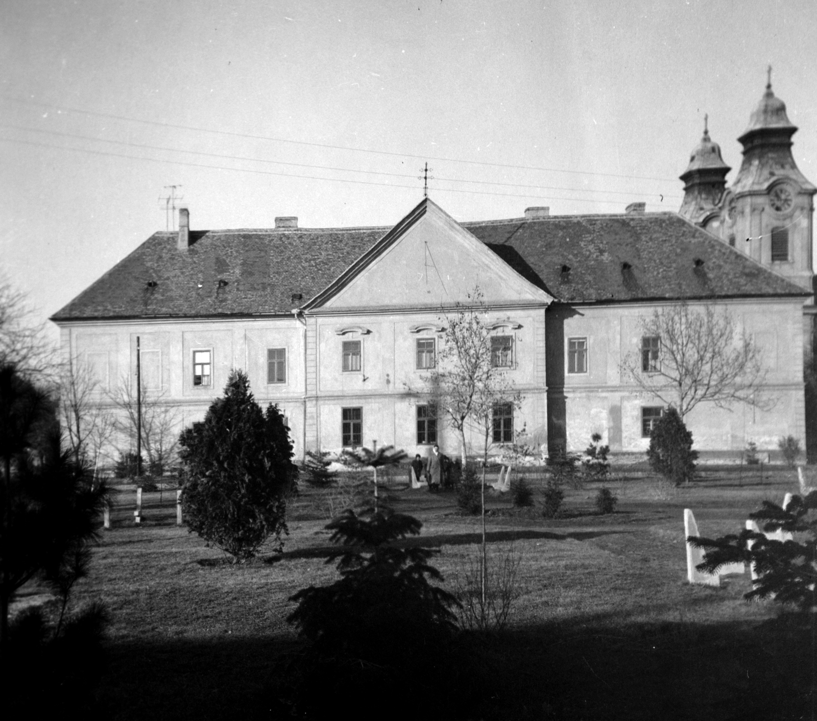 Magyarország, Celldömölk, Szentháromság (Tanácsköztársaság) tér, a Járási Tanács épülete (az egykori bencés kolostor és rendház), jobbra a háttérben a Nagyboldogasszony-kegytemplom tornyai., 1965, Dervarits Diána és Póth Attila, Fortepan #272368