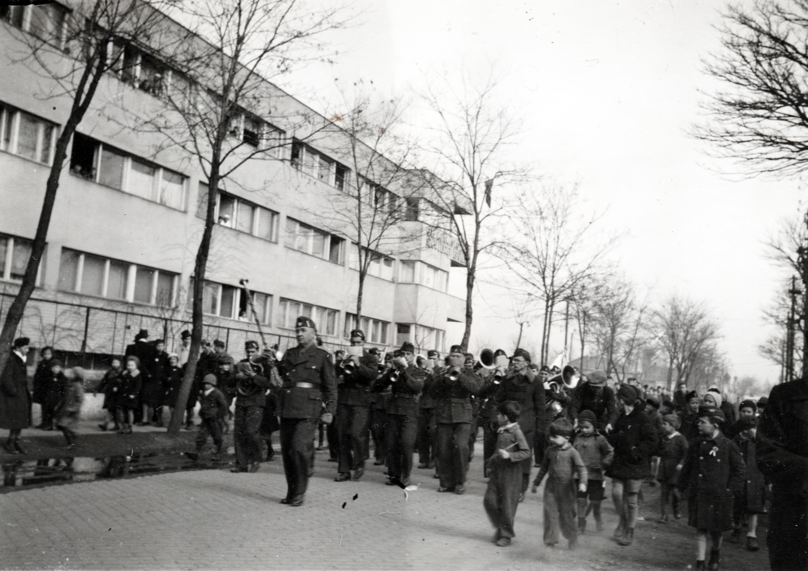 Hungary, Budapest XIV., Pestújhelyi út, katonazenekar a 40-es szám alatti Országos Társadalombiztosítási Intézet (OTI) Dr. Vass József Munkáskórházának személyzeti épülete előtt., 1940, Hózer Benjamin, musical instrument, military band, drum major, youth military organisation, trumpet, wind band, Budapest, Fortepan #272544