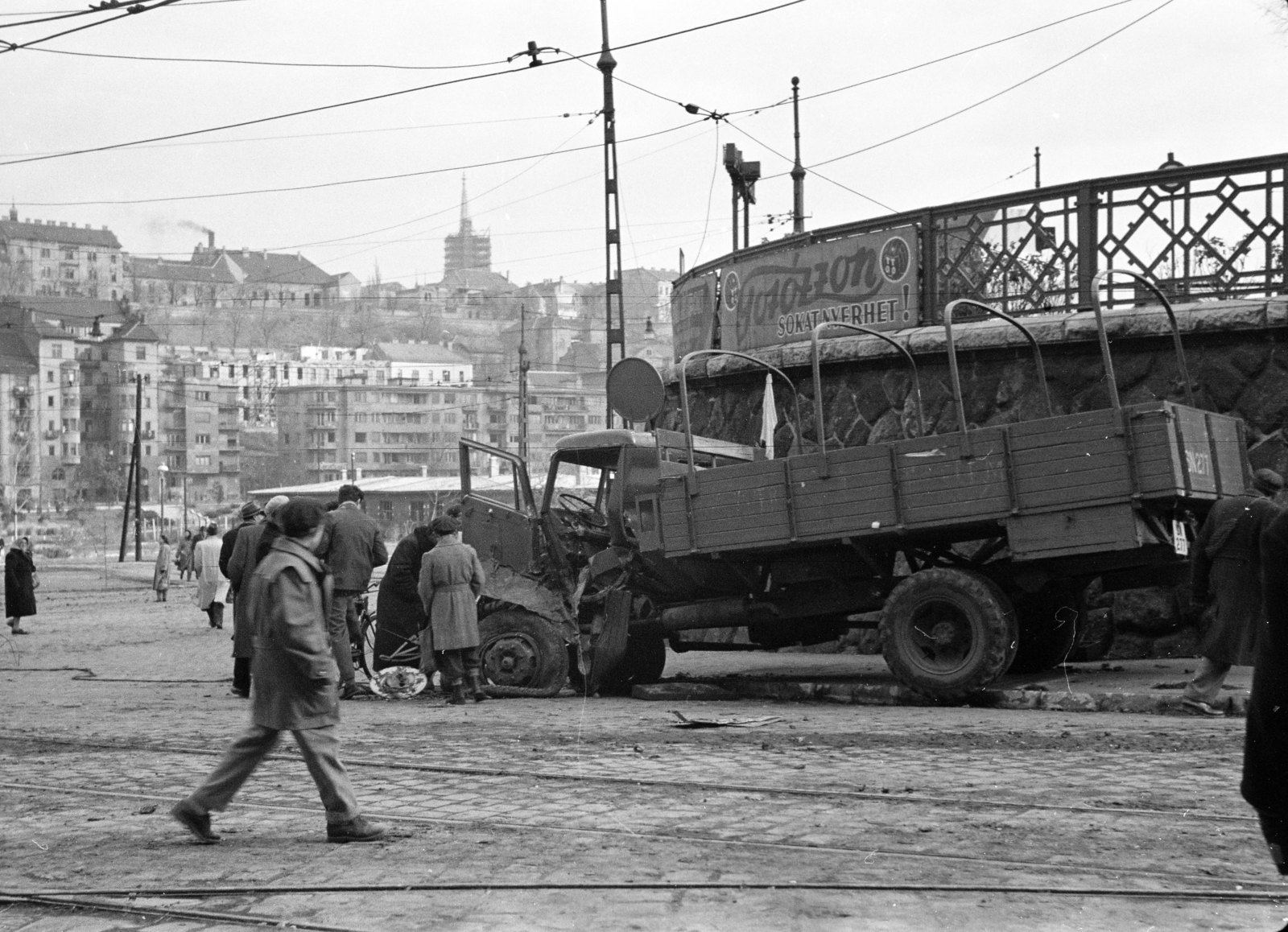 Hungary, Budapest I., Alkotás utca, teherautó roncsa a Déli pályaudvar előtt, háttérben a Vérmező és az Attila útházsora. Fenn a budai Várban a Mátyás-templom felújítás alatt álló tornya látható., 1956, Papp Dezső, Best of, railway turntable, commercial vehicle, Budapest, street view, label, 1st of May parade, Fortepan #272689