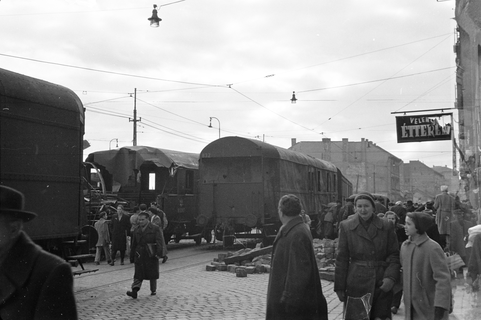 Magyarország, Budapest XII.,Budapest I., Alkotás utca, a Déli pályaudvarról kitolt, az 1956-os forradalom alatt barikádnak használt vasúti kocsik., 1956, Papp Dezső, járókelő, járműroncs, cégtábla, Budapest, Fortepan #272690