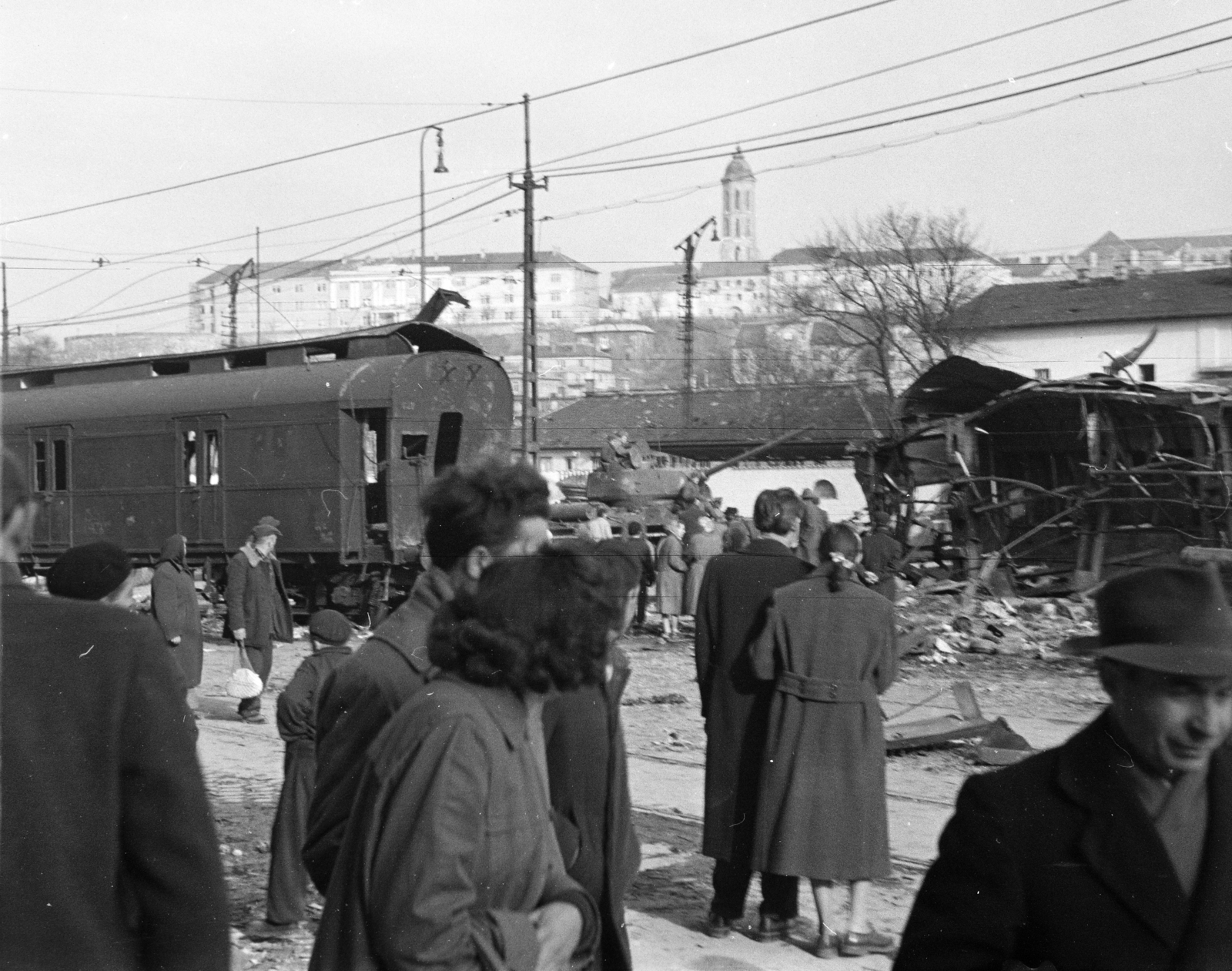 Magyarország, Budapest I., Alkotás utca, a Déli pályaudvarról kitolt, az 1956-os forradalom alatt barikádnak használt vasúti kocsik, fenn a Várban a Hadtörténeti Múzeum és a Mária Magdolna-templom tornya látszik., 1956, Papp Dezső, járműroncs, kíváncsiság, vagon, Budapest, Fortepan #272752