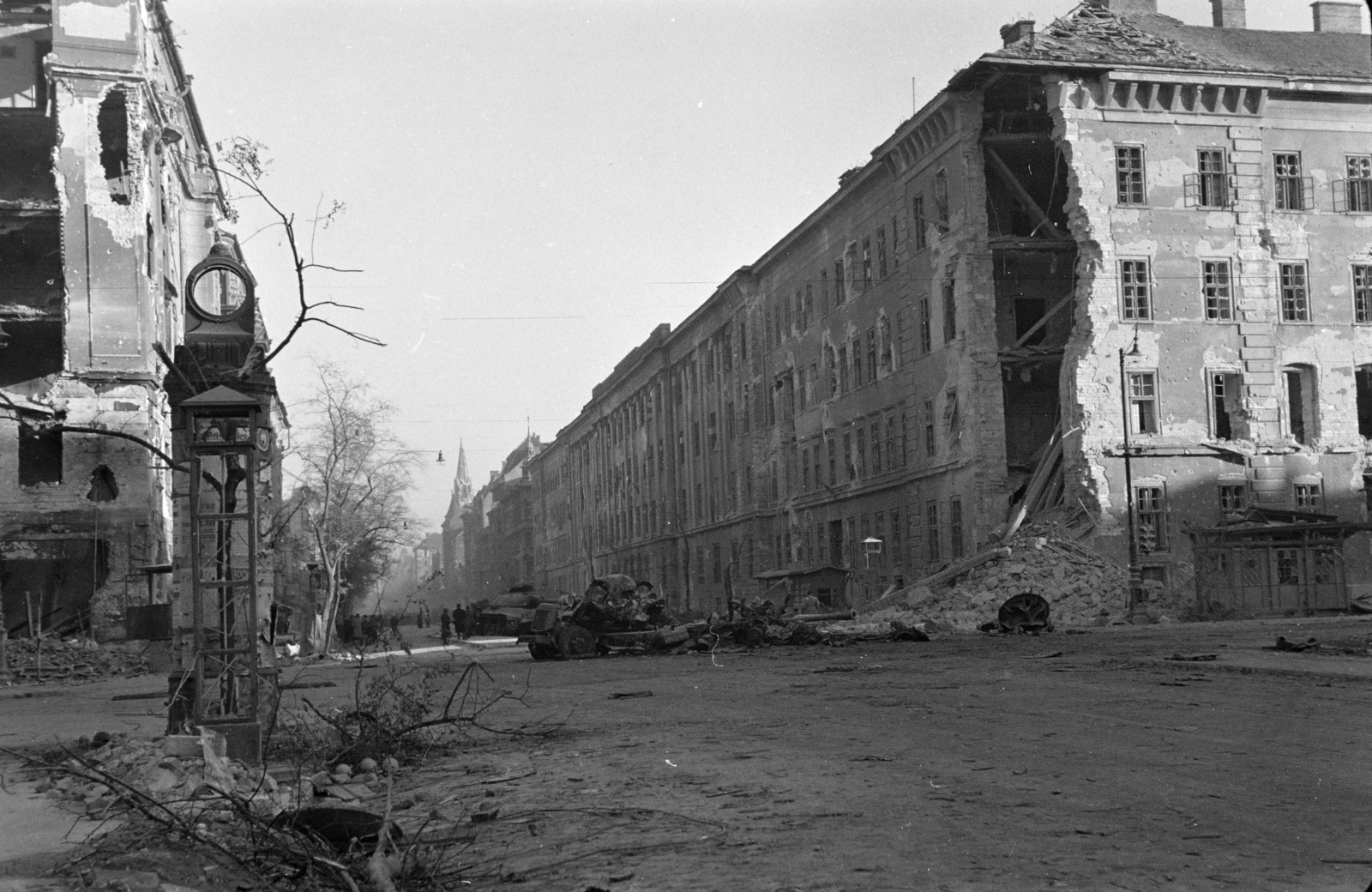 Hungary, Budapest VIII.,Budapest IX., Üllői út a Nagykörút kereszteződésénél, jobbra a Ferenc körút sarkán a romos Kilián laktanya., 1956, Papp Dezső, damaged building, wreck, public clock, public toilet, steeple, intersection, ad pillar, Budapest, Fortepan #272766