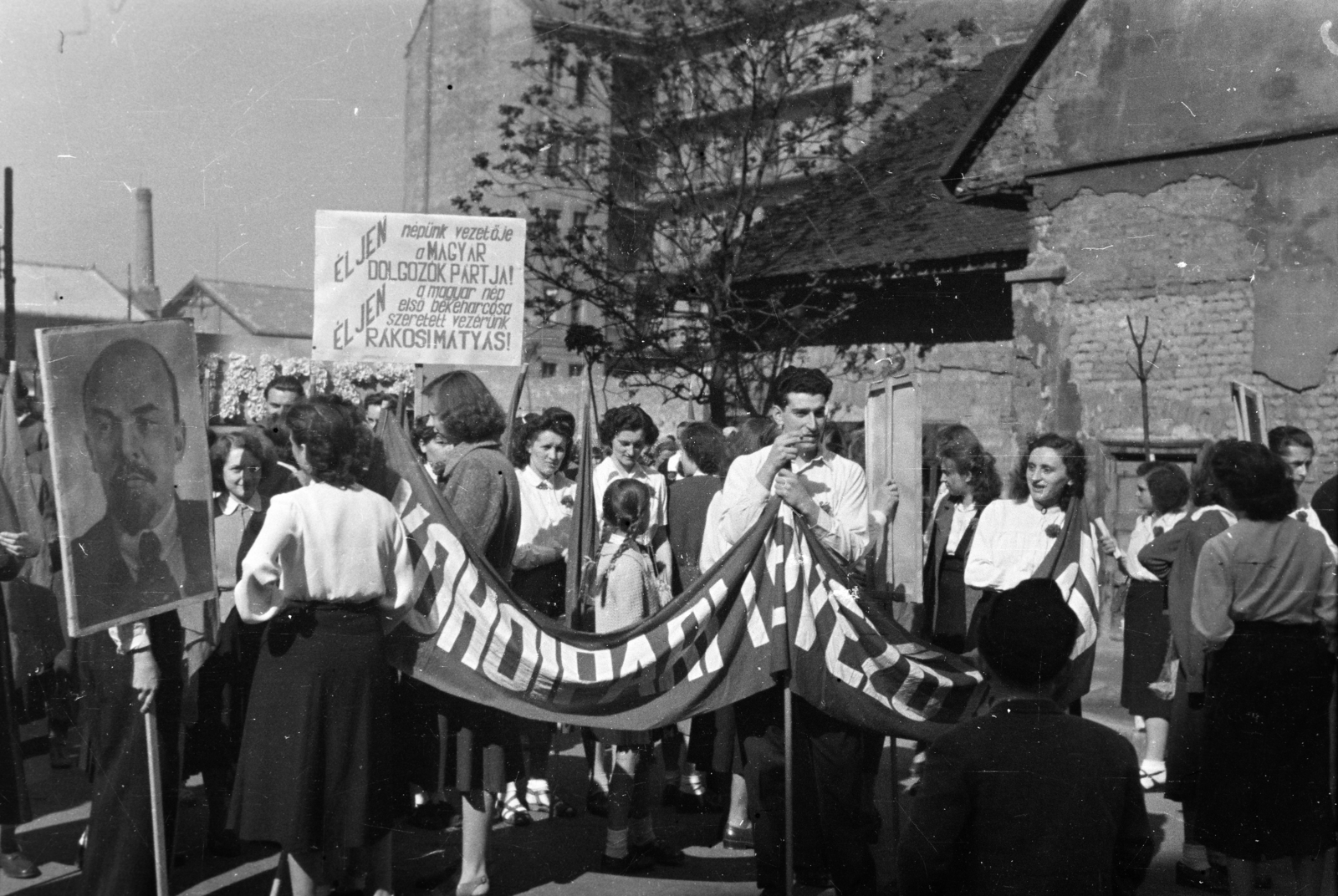 Hungary, Budapest IX., Kinizsi utca, a Kohóipari Tervező Intézet dolgozói május 1-i felvonulásra gyülekeznek az 1-7. szám alatti épülettömb előtt. Háttérben a Közraktár utca 12/b számú ház udvar felőli homlokzata látható., 1951, Kern család, march, Lenin-portrayal, banner, Budapest, Fortepan #273233