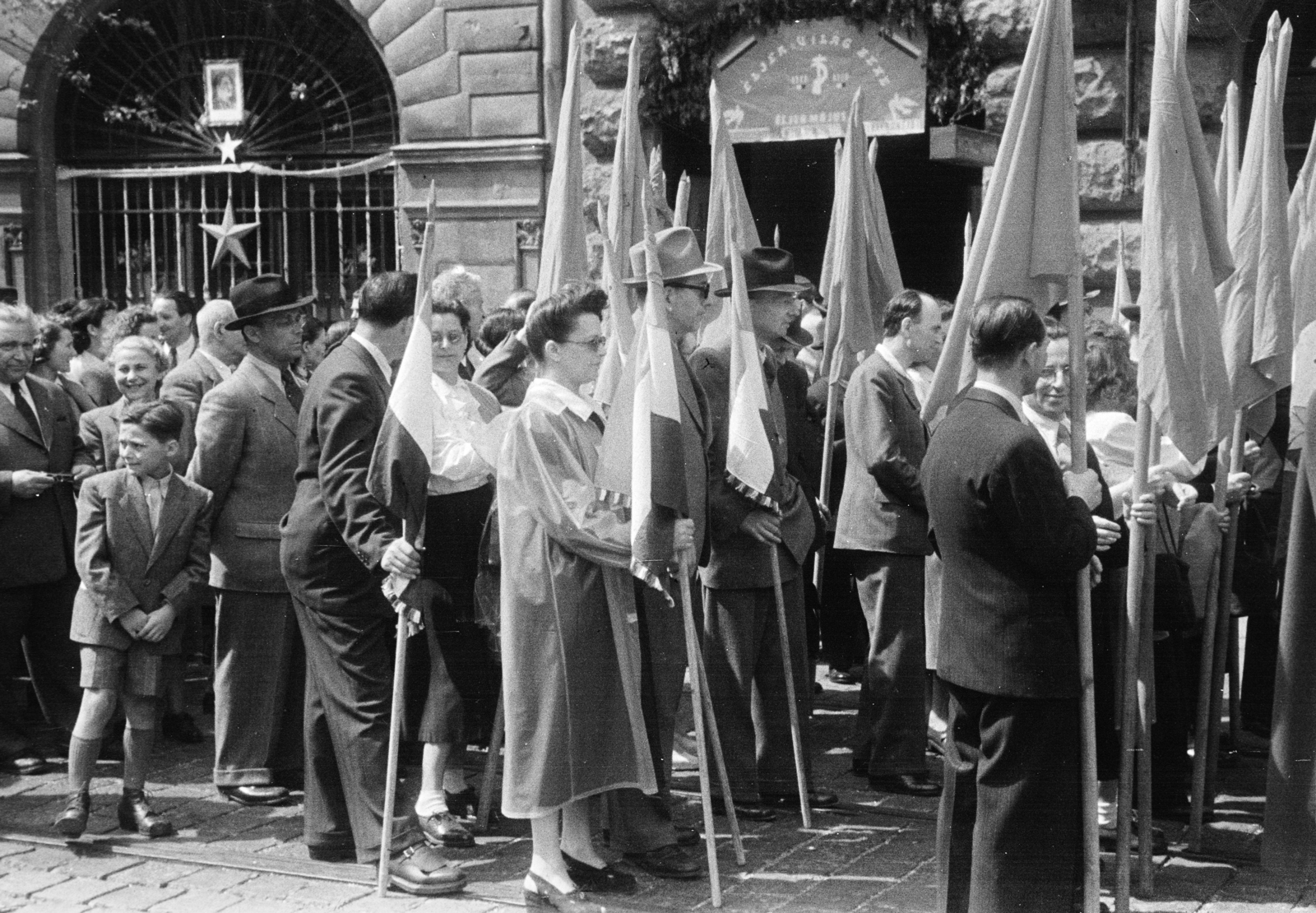 Hungary, Budapest V., Vértanúk tere (Ságvári tér), felvonulás résztvevői. A felvétel a Kossuth Lajos tér sarkán álló ház előtt készült, balra a Nádor utca 36-os számú épület., 1950, Kern család, Budapest, Red Star, waiting, march, flag, Fortepan #273326