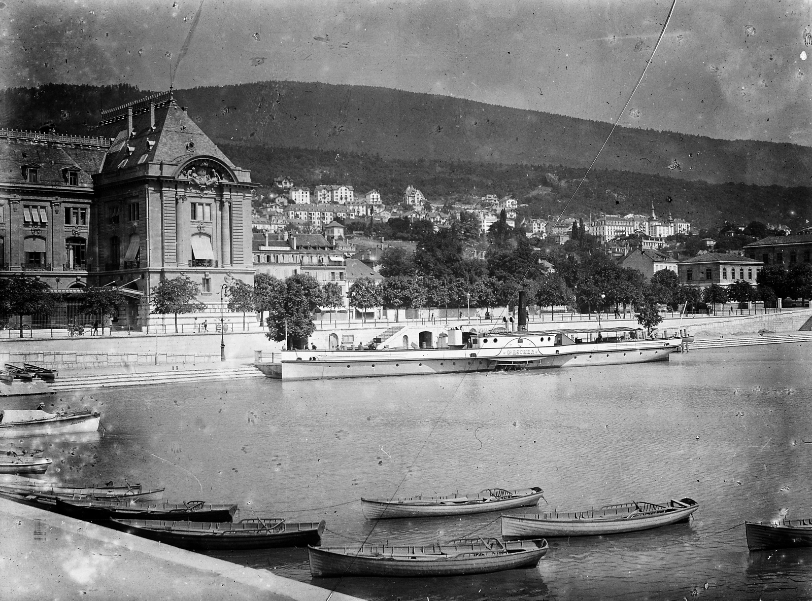 Svájc, Neuchâtel, Neuchâteli-tó / Neuenburgersee, kikötő. Szemben a Quai du Port, balra a főposta és az idegenforgalmi hivatal székhelye, jobbra, távolabb a Hotel Terminus., 1909, Bojér Tibor, csónak, látkép, hegy, öböl, Fortepan #276041