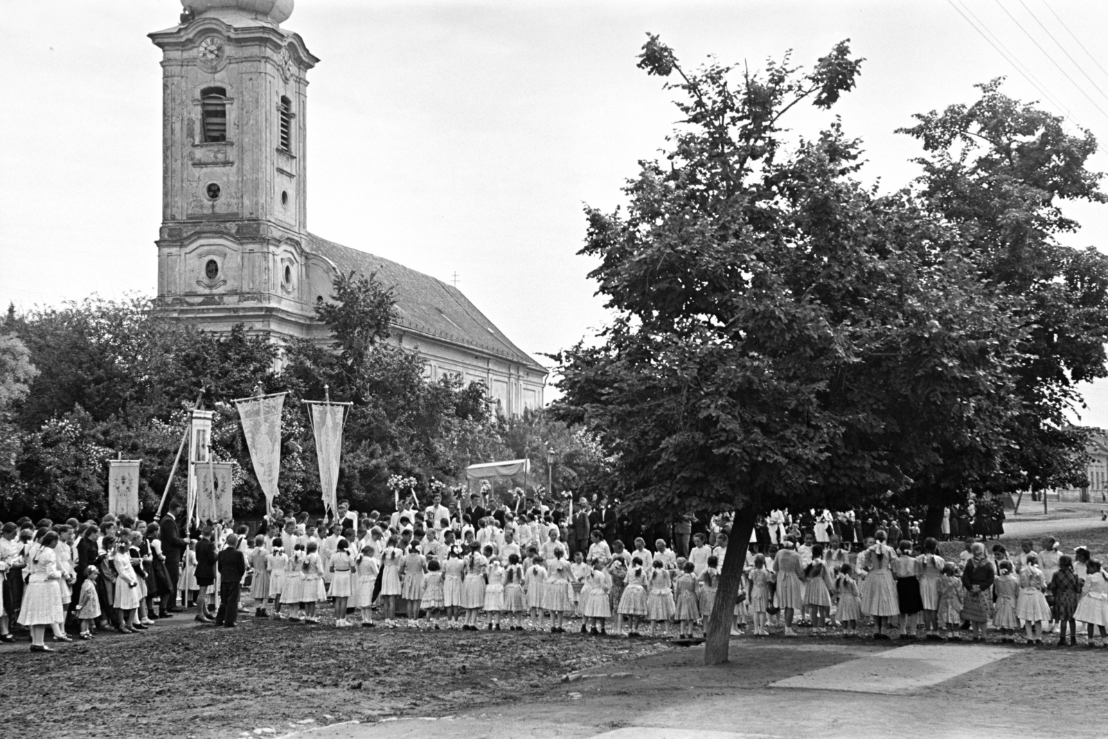 Magyarország, Érsekvadkert, Rákóczi út, úrnapi körmenet részvevői, háttérben a Szent András-templom., 1957, Hámori Gyula, körmenet, Fortepan #276175