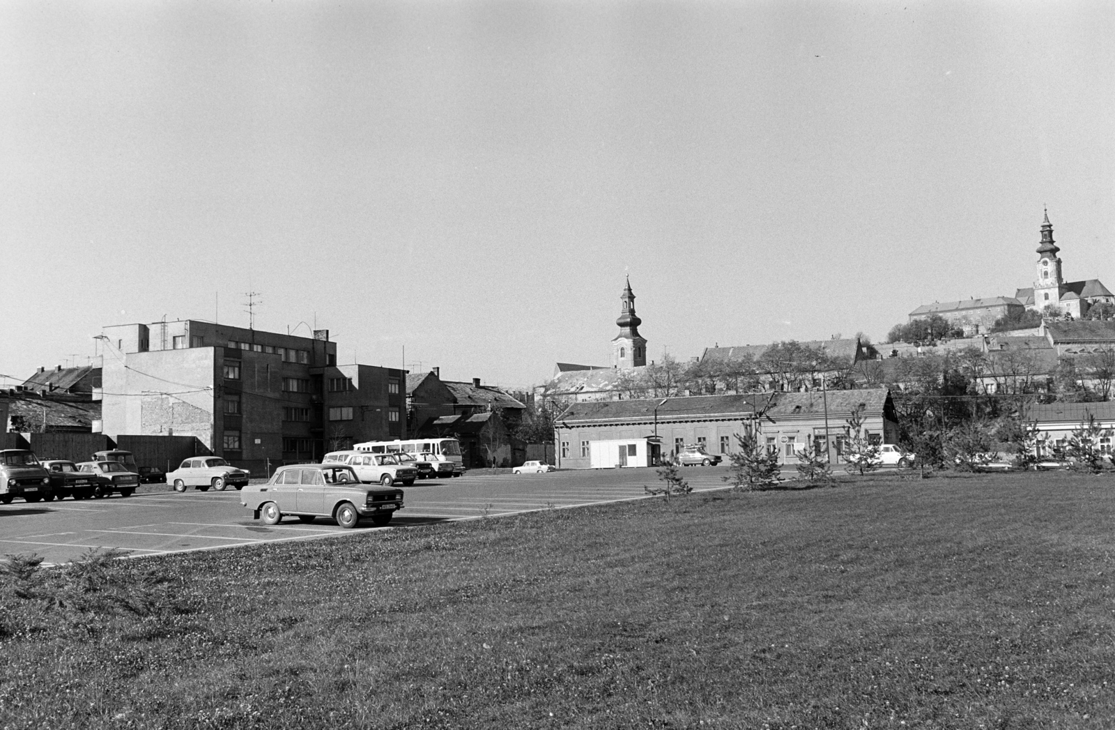 Slovakia, Nitra, Svätoplukovo námestie, balra a Szent Péter és Pál templom (Kostol sv. Petra a Pavla), jobbra a Várdombon fenn a vár és a Vártemplom, 1979, Obetkó Miklós, car park, Fortepan #277142