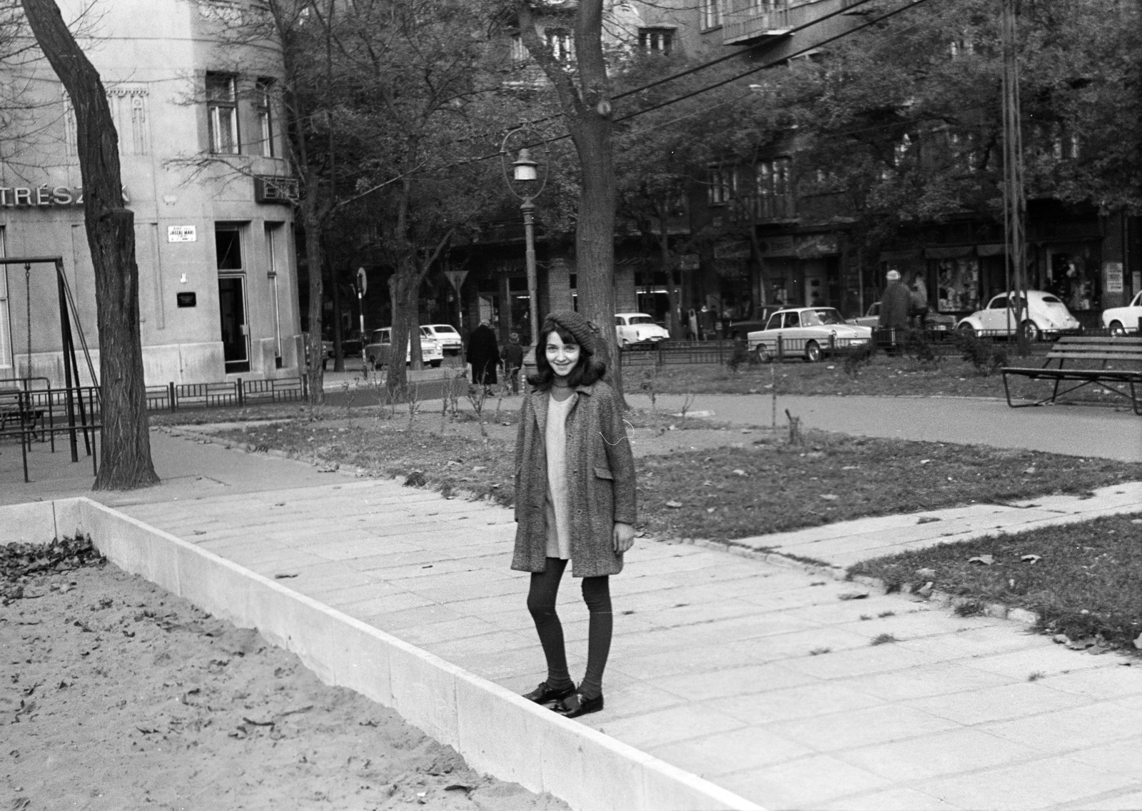 Hungary, Budapest XIII., Jászai Mari tér, játszótér. Háttérben a Pozsonyi út - Budai Nagy Antal utca sarkán álló házak láthatók., 1970, Obetkó Miklós, Volkswagen Beetle, Volkswagen-brand, Budapest, street view, cap, smile, coat, teenager, hairdo, street name sign, girl, Fortepan #277232