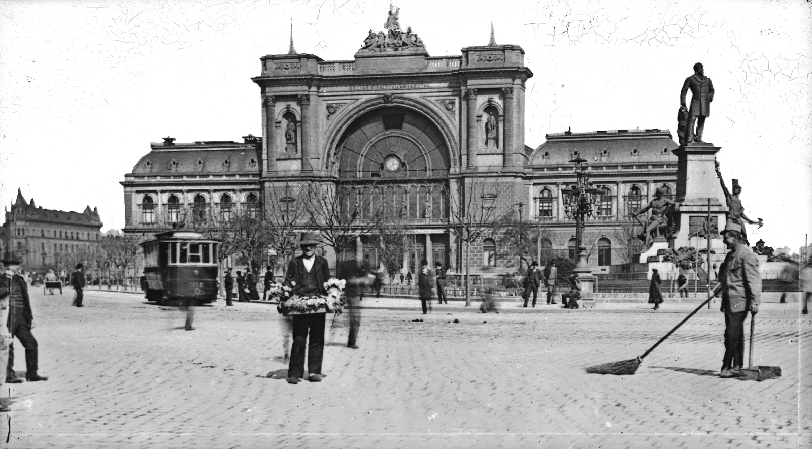 Magyarország, Budapest VII.,Budapest VIII., Baross tér, szemben a Keleti pályaudvar, jobbra Baross Gábor szobra (Szécsi Antal, 1898.)., 1904, Deutsche Fotothek / Brück und Sohn, épületdísz, épületszobor, utcaseprő, Feketeházy János-terv, Rochlitz Gyula-terv, pályaudvar, virágárus, köztéri óra, Budapest, árus, Fortepan #277690