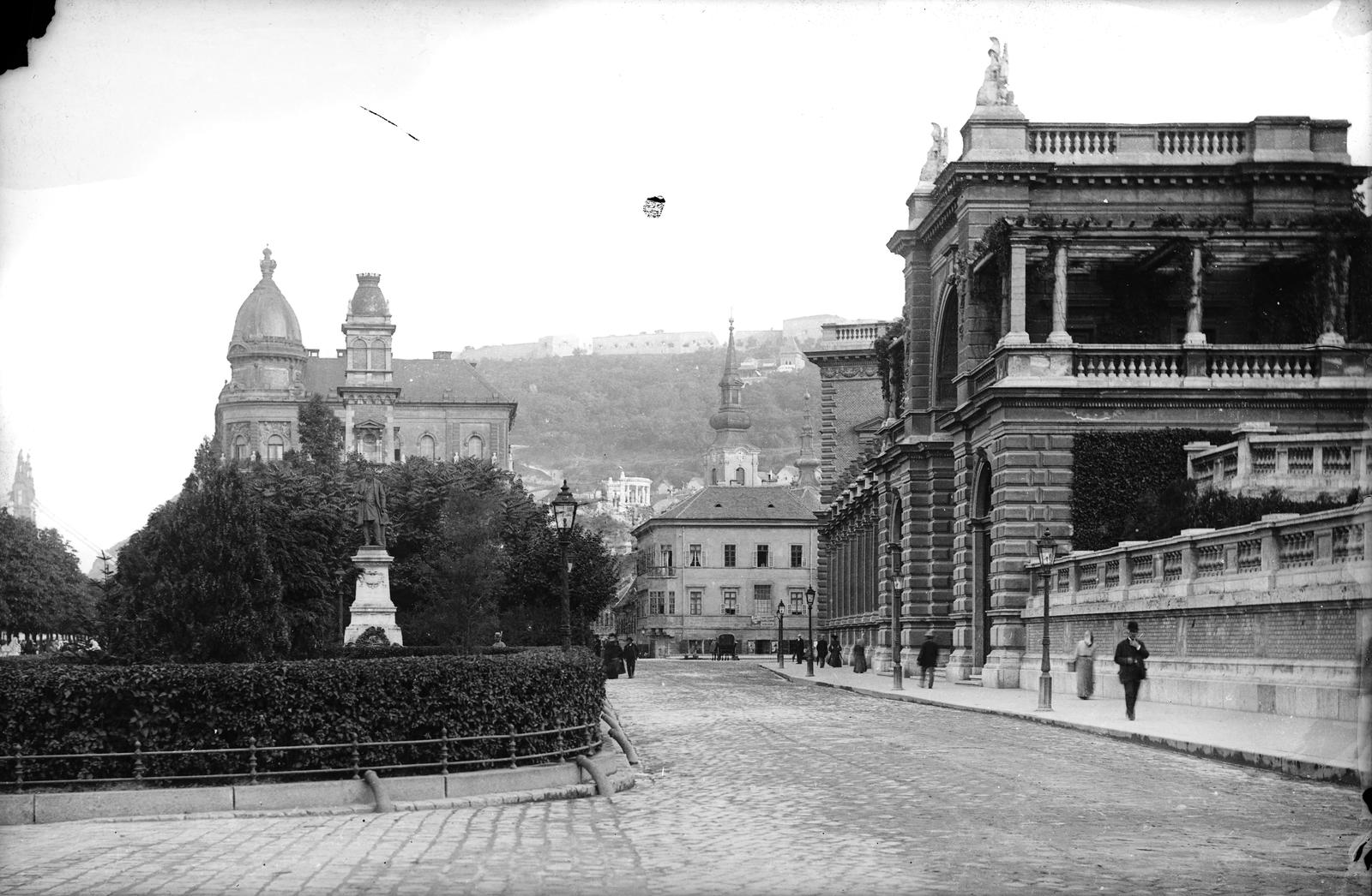 Magyarország, Budapest I., Ybl Miklós tér, szemben Ybl Milós szobra (Mayer Ede, 1986.), mögötte a Várkert Kioszk tornya és a Várkert rakpart (Zita királyné út) 7. a Lyka-palota sarok kupolája látszik. Jobbra a Várkert Bazár,, 1904, Deutsche Fotothek / Brück und Sohn, szobor, Ybl Miklós-terv, Ybl Miklós-ábrázolás, Budapest, Fortepan #277703