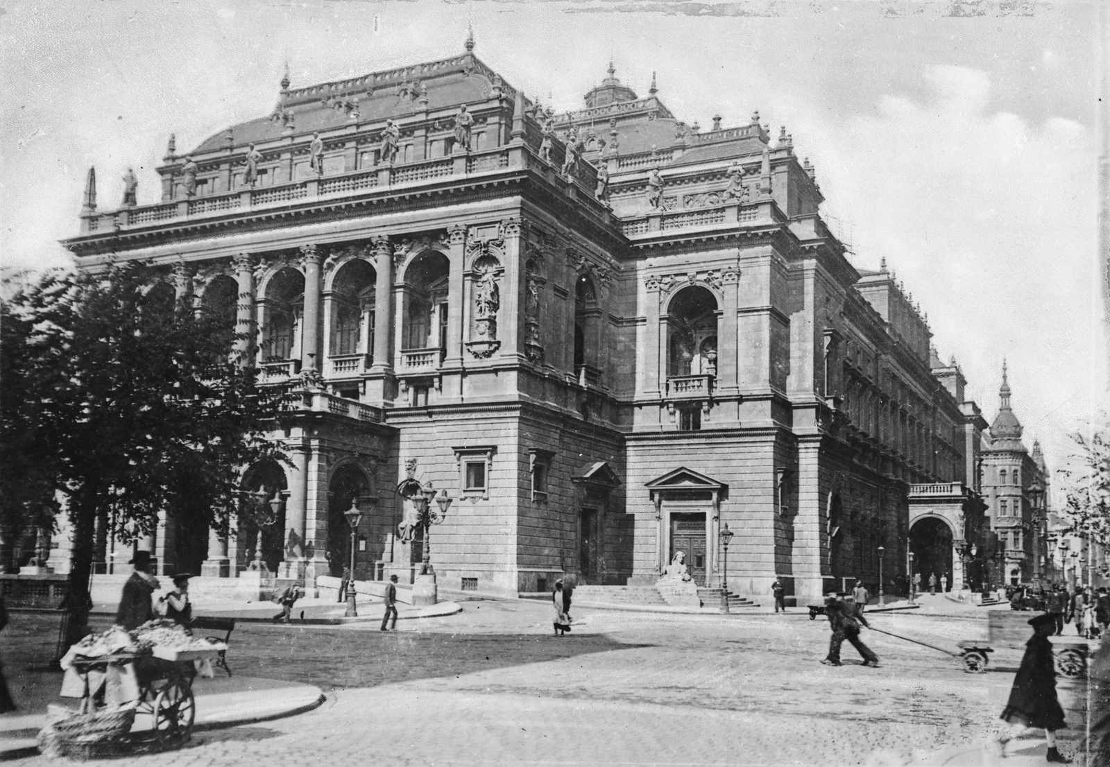 Magyarország, Budapest VI., Hajós utca - Andrássy út kereszteződése, szemben a Magyar Állami Operaház épülete (Ybl Miklós, 1884.)., 1904, Deutsche Fotothek / Brück und Sohn, gázlámpa, középület, kézikocsi, épületdísz, kocsifelhajtó, színház, szfinx, árus, szoborfülke, Ybl Miklós-terv, operaház, Budapest, Fortepan #277716