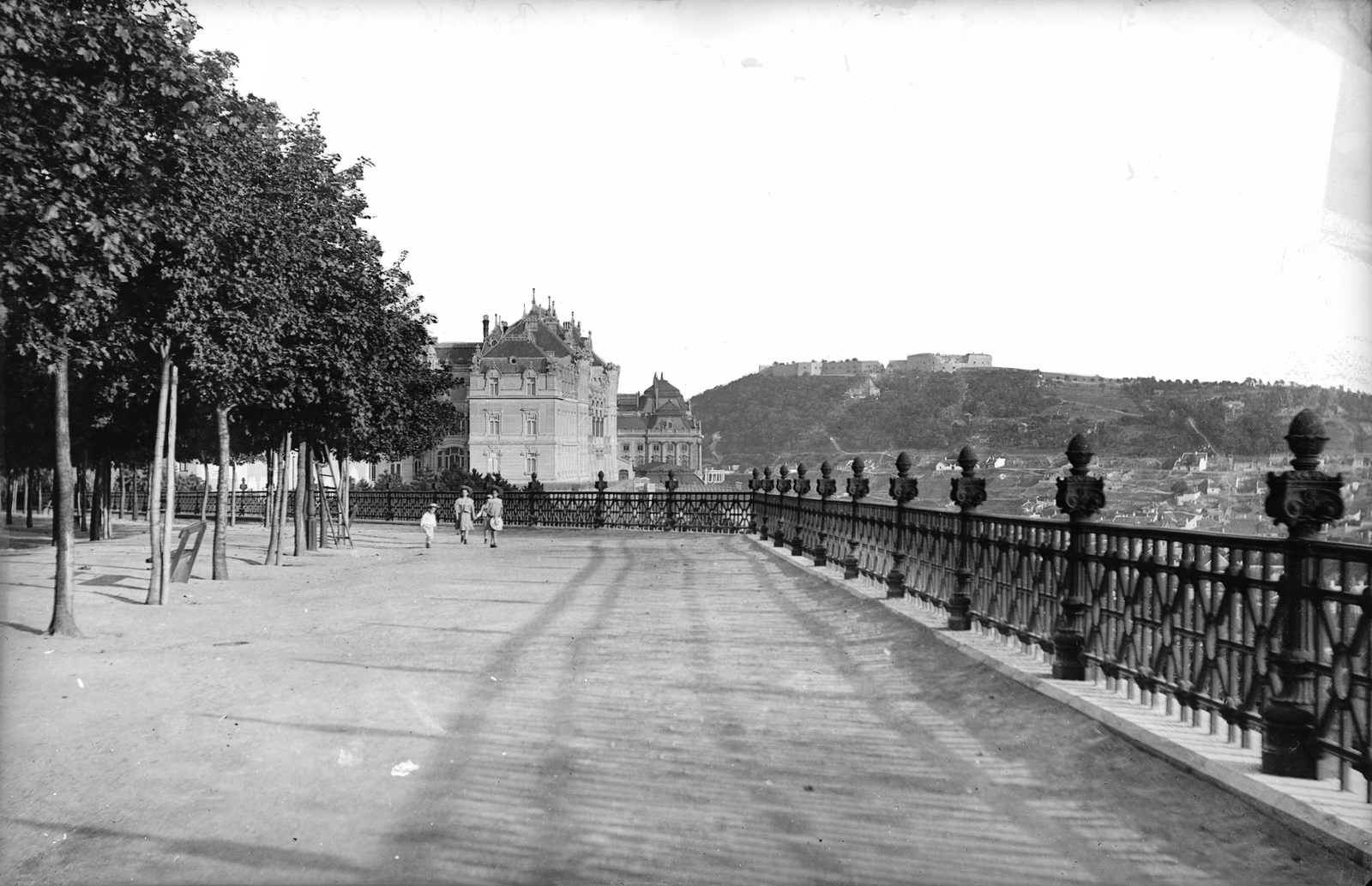 Magyarország, budai Vár, Budapest I., Tóth Árpád (Bástya) sétány, szemben a József főhercegi palota, mögötte a Királyi Palota (később Budavári Palota), jobbra a Gellért-hegy és a Citadella., 1905, Deutsche Fotothek / Brück und Sohn, korlát, fasor, sétány, Budapest, Fortepan #277765