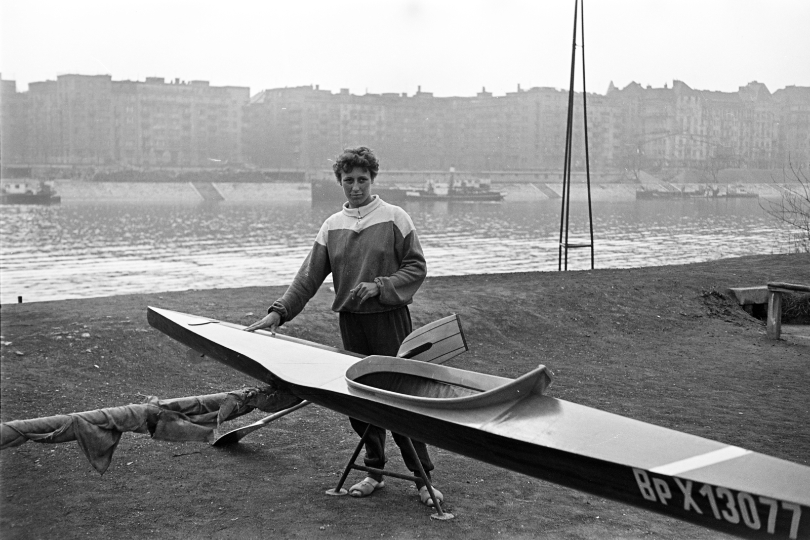 Magyarország, Margitsziget, Budapest, Tolnai Ilona kajakozó. A Duna túlpartján az Újpesti rakpart házsora, jobbra a Palatinus házak., 1957, Artfókusz, Fábián József, Best of, nő, lapát, folyó, épület, evező, kajak, Duna, Fortepan #278415