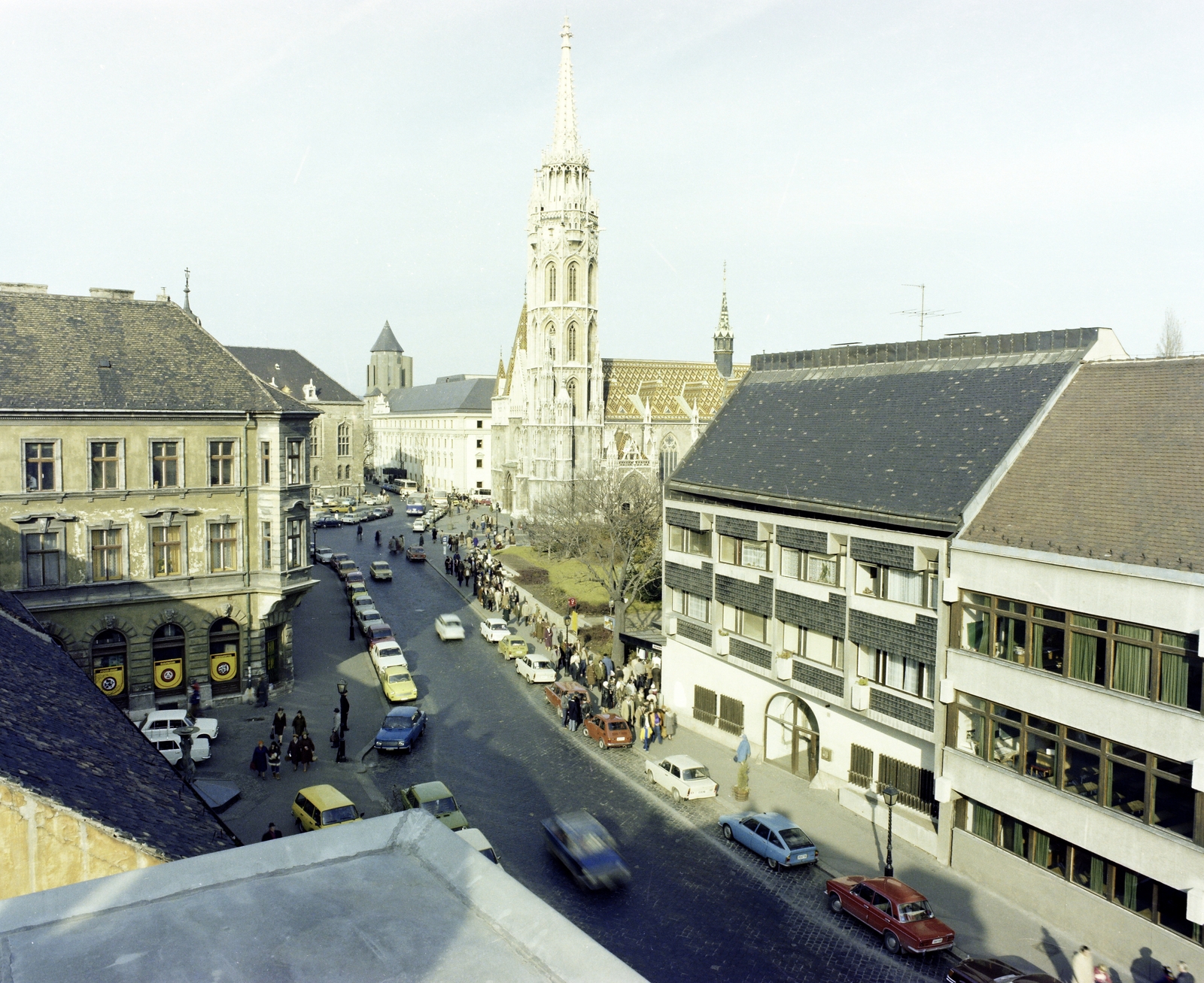 Hungary, Budapest I., kilátás az Anna utca sarkán álló Tárnok utca 16-os számú épületről a Szentháromság tér, a Mátyás-templom felé. Jobbra a 13-as számú ház, mellette a 9-11. szám alatti Budavári Általános Iskola épülete., 1982, Artfókusz, Budapest, street view, church, automobile, house, Fortepan #280210