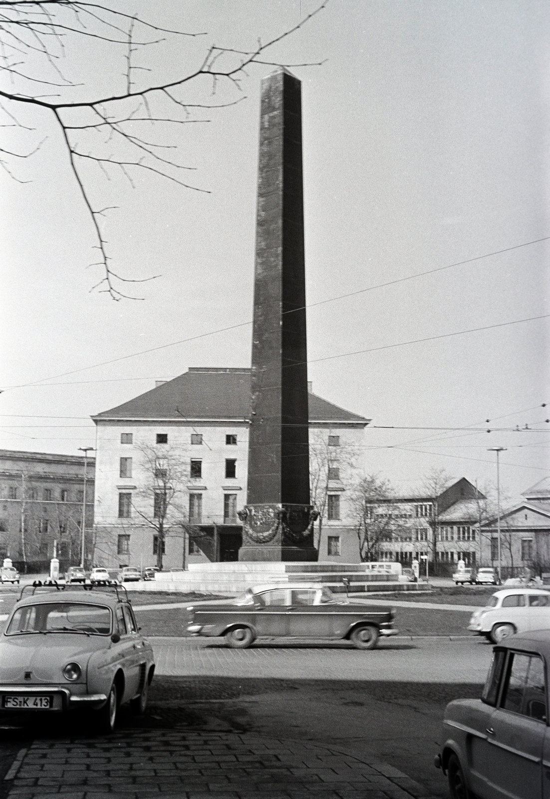 Németország, München, Karolinenplatz, Obeliszk Napóleon 1812-es orosz hadjáratában elesett 30 000 bajor katona tiszteletére. Háttérben a Német Tudományos és Műszaki Akadémia épülete., 1963, Artfókusz, Fábián József, Fortepan #280341