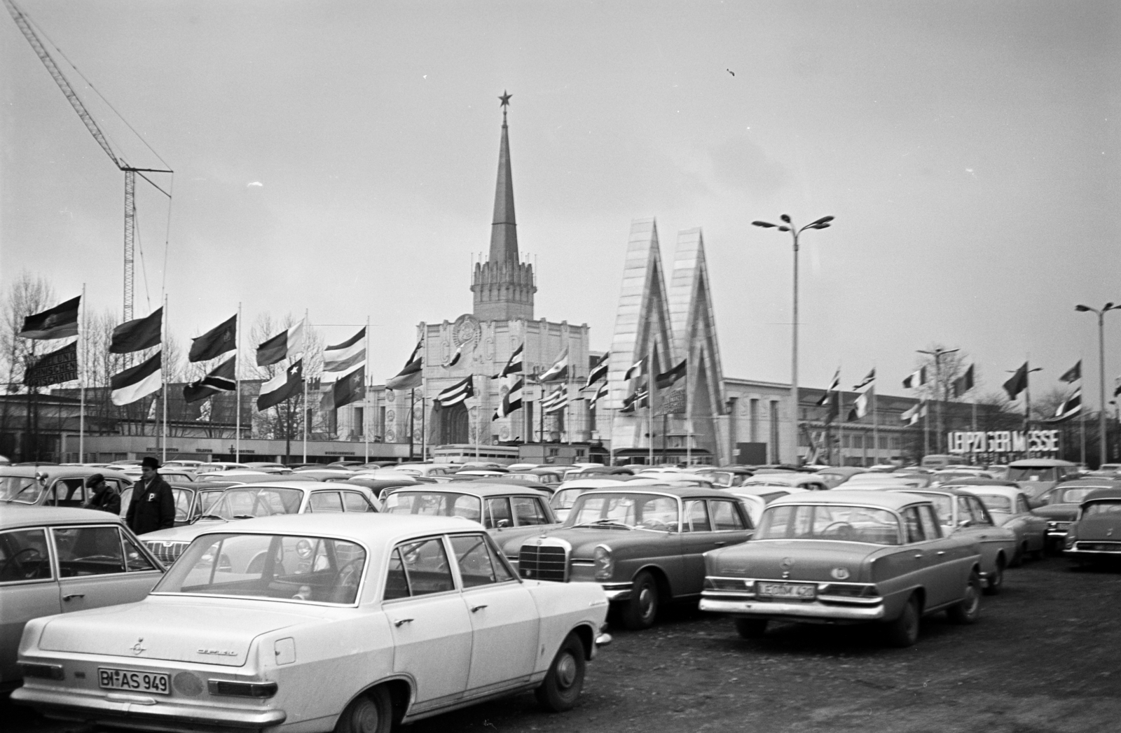 Németország, Lipcse, a vásárterület parkolója, Lipcsei Vásár. Háttérben 1923-1924 -ben épült kiállítóterem az Achilleion. Az 1950-es évek elején átalakították, szovjet kiállítás pavilonjának, később a levéltár használatába került., 1967, Artfókusz, Fábián József, parkoló, NDK, Fortepan #280487