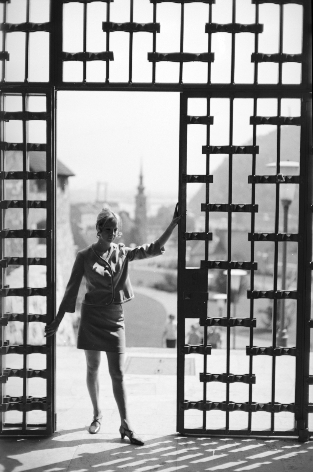Magyarország, budai Vár, Budapest I., kilátás a Ferdinánd-kapuból az Alexandriai Szent Katalin-templom felé., 1967, Artfókusz, Fábián József, miniszoknya, árnyék, vaskapu, Budapest, Fortepan #280690