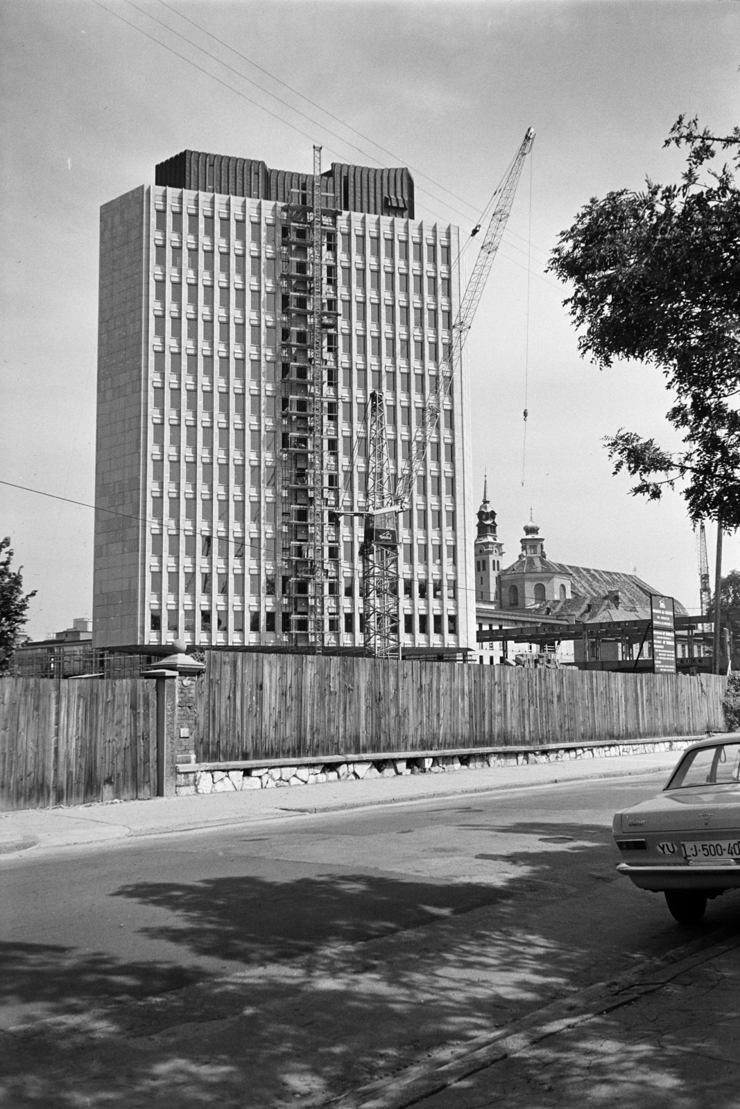 Szlovénia, Ljubljana, Erjavčeva cesta, szemben az épülő TR2-toronyház a Trg Republike-n, mögötte jobbra a háttérben a Szentháromság-templom., 1969, Artfókusz, Fábián József, Jugoszlávia, Fortepan #280821