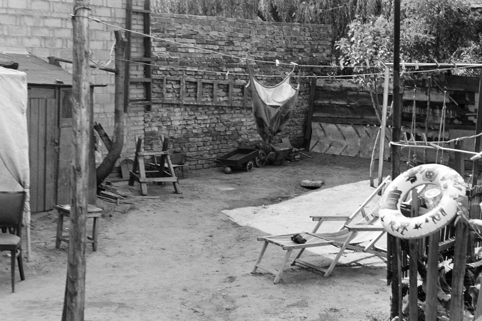 A kép forrását kérjük így adja meg: Fortepan / Budapest Főváros Levéltára. Levéltári jelzet: HU.BFL.XV.19.c.10, 1972, Budapest Főváros Levéltára / BRFK helyszínelési fényképei, BRFK Hivatala Bűnügyi Technikai Osztály, udvar, téglafal, úszógumi, nyugágy, fűrészbak, teregetés, fürdőruha, ruhaszárító, Fortepan #281672