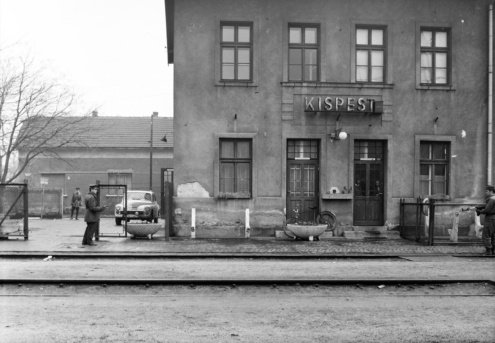 Hungary, Budapest XIX., Kispest vasútállomás, háttérben a Liszt Feren utca 32-es számú ház látható. A kép forrását kérjük így adja meg: Fortepan / Budapest Főváros Levéltára. Levéltári jelzet: HU.BFL.XV.19.c.10, 1971, Budapest Főváros Levéltára / BRFK helyszínelési fényképei, BRFK Hivatala Bűnügyi Technikai Osztály, Best of, cop, soldier, peeking, weapon, train station, Budapest, Fortepan #284340