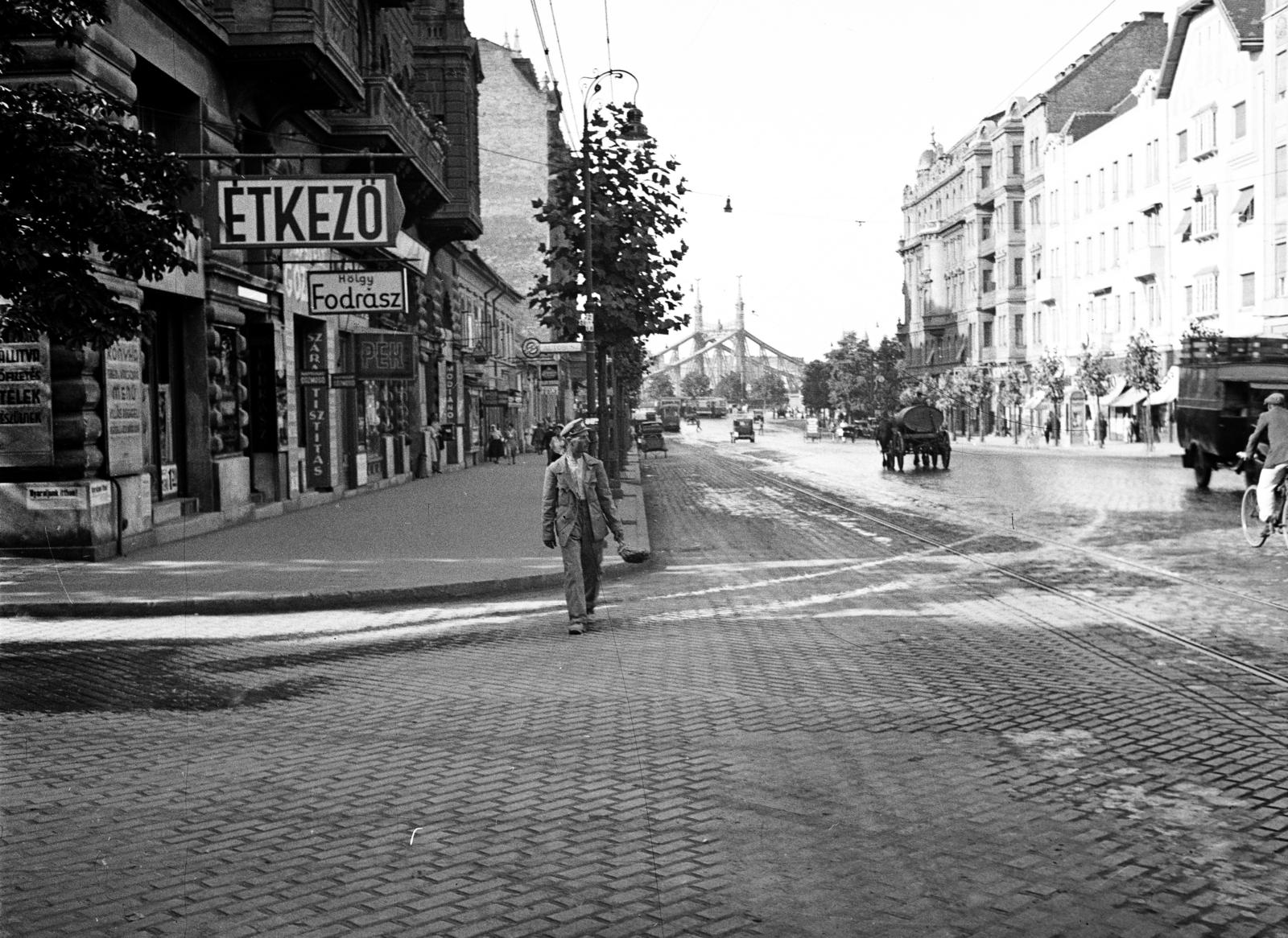 Magyarország, Budapest XI., Bartók Béla (Horthy Miklós) út, balra az Orlay utca torkolata. A távolban a Szent Gellért térnél a Szabadság (Ferenc József) híd látszik., 1936, Gara Andor, Best of, felirat, fodrászat, kerékpár, locsolás, járókelő, utcakép, Budapest, Fortepan #285352