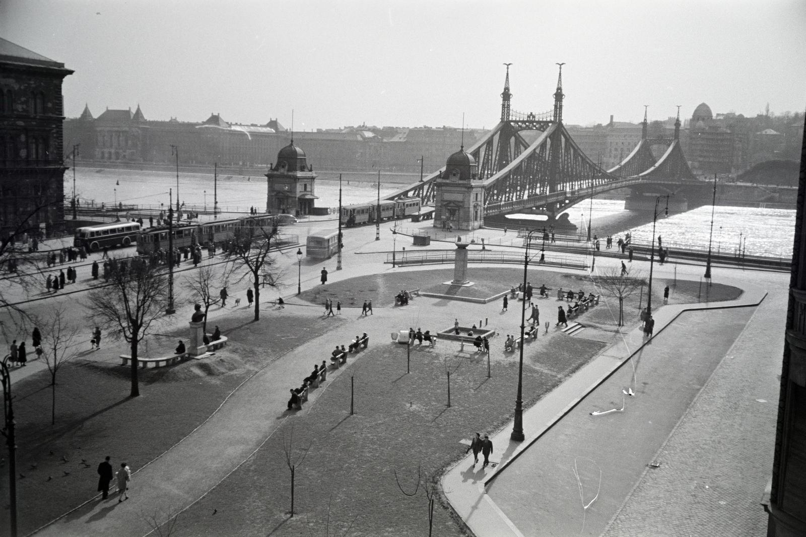 Hungary, Budapest V.,Budapest IX.,Budapest XI., kilátás a Só utca 2-es számú ház erkélyéről a Fővám (Dimitrov) térre, ott az I. honvéd és népfelkelő gyalogezred emlékoszlopa (Domján Árpád, 1949.). Szemben a Szabadság híd, háttérben balra a Budapesti Műszaki Egyetem (később Budapesti Műszaki és Gazdaságtudományi Egyetem) épületei., 1955, Gara Andor, Budapest, Fortepan #285405