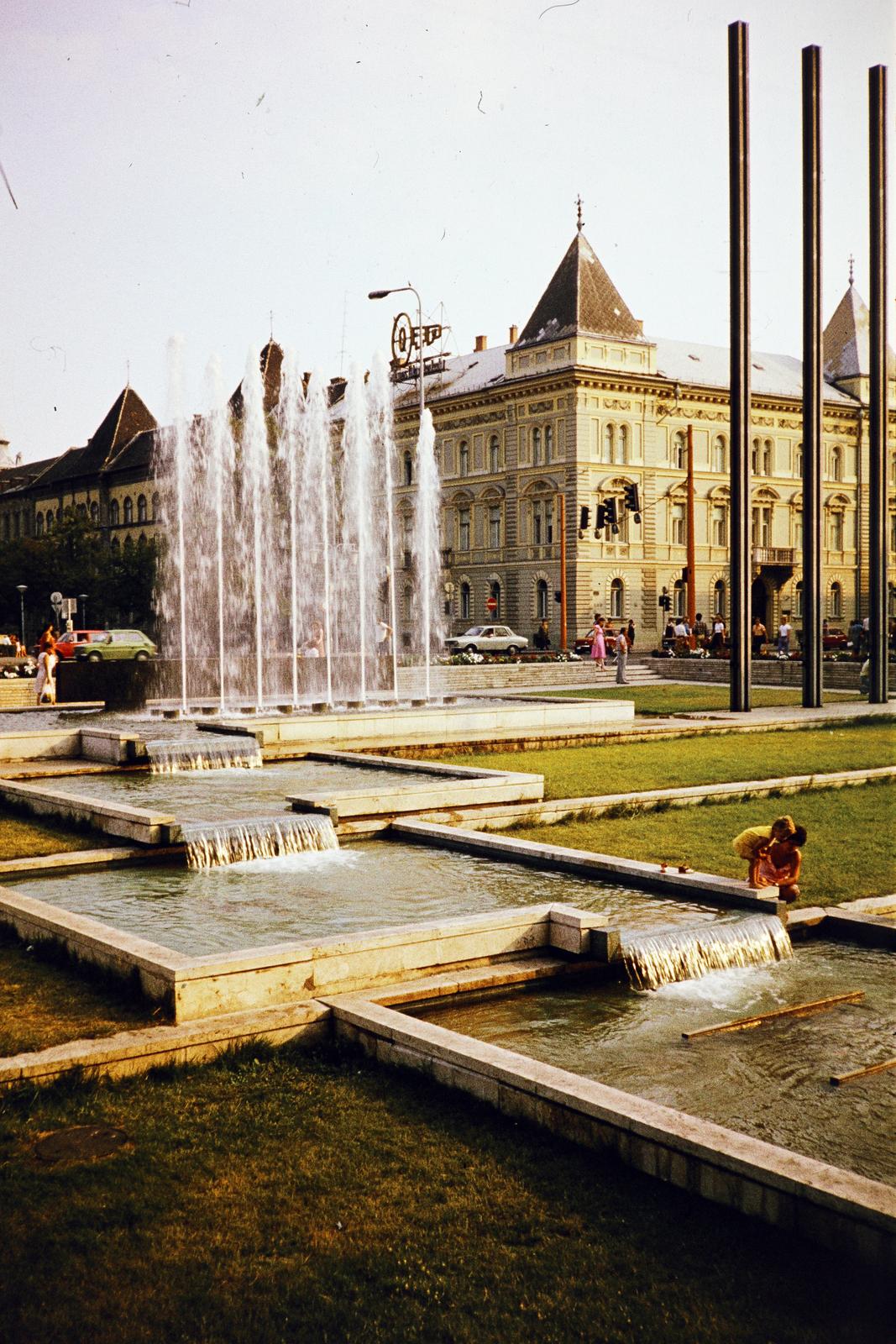 Hungary, Győr, Városház (Szabadság) tér, a szökőkút mögött a Szent István út (Tanácsköztársaság útja) sarkán álló épület látható., 1982, Kozák, colorful, Fortepan #286729