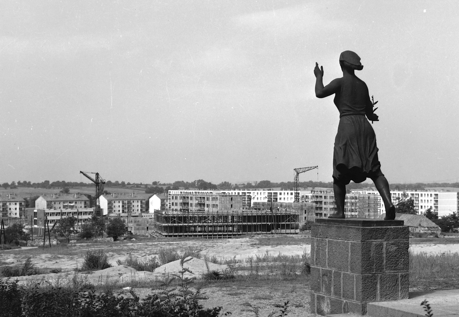 Magyarország, Oroszlány, Felszabadulási emlékmű (Ungvári Lajos, 1958.), mely Zója Koszmogyemjanszkaja, a Szovjetunió Hőse alakját örökíti meg. Szemben az épülő Tanácsháza (később Polgármesteri Hivatal)., 1963, Építésügyi Dokumentációs és Információs Központ, VÁTI, szobor, építkezés, szocreál, Fortepan #28723