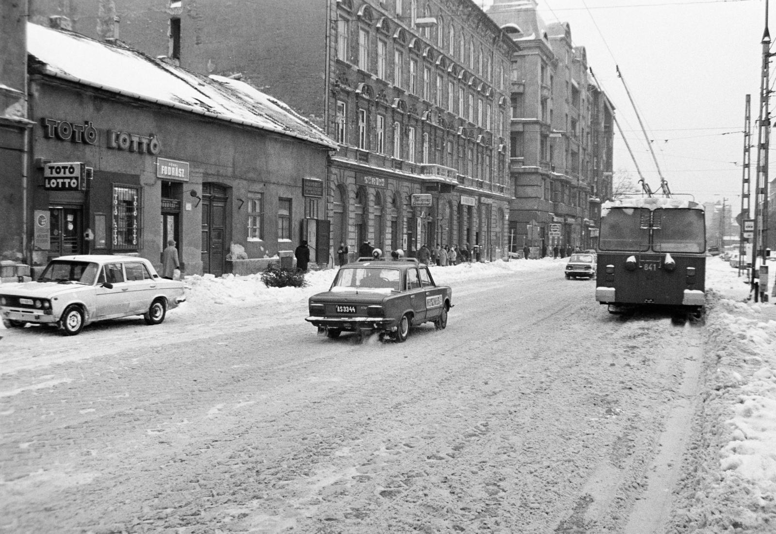 Hungary, Budapest VIII., Baross utca, trolibuszmegálló a Baross kocsiszín előtt. Balra a Szeszgyár utca torkolata., 1987, Prohászka Imre, Best of, trolley bus, Budapest, number plate, Lada-brand, winter, crime scene investigation, lottery retailer, Fortepan #288745