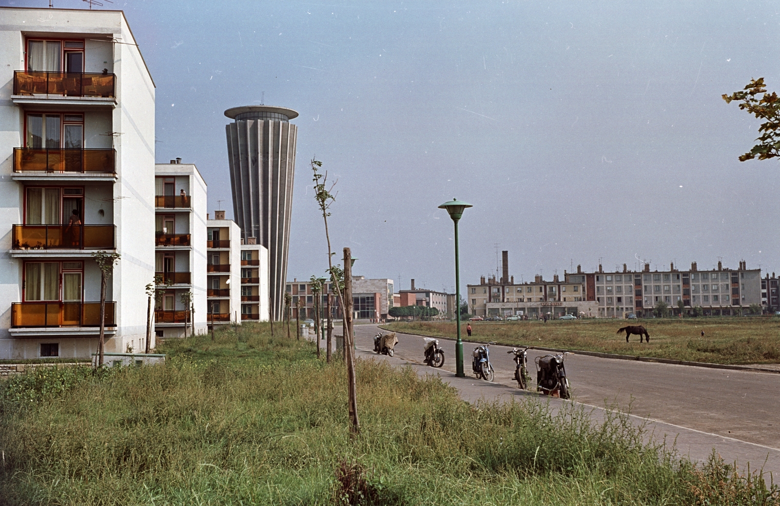 Hungary, Tiszaújváros, (Tiszaszederkény) Tisza út a Kazinczy út felöl nézve, háttérben a víztorony., 1966, Építésügyi Dokumentációs és Információs Központ, VÁTI, colorful, motorcycle, horse, blocks, water tower, odd one out, Fortepan #28921