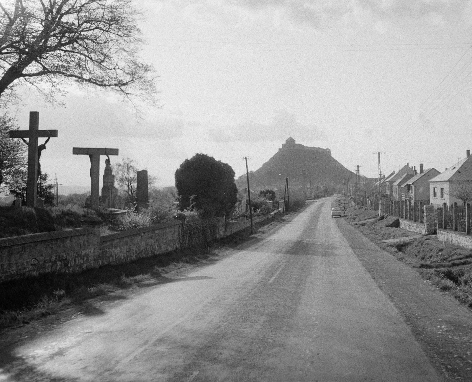 Hungary, Sümeg, Tapolcai utca, balra a temető kápolna melletti kőkeresztek, távolban a vár látható., 1975, Bencseky Mátyás, cross, street view, castle, picture, Fortepan #289703